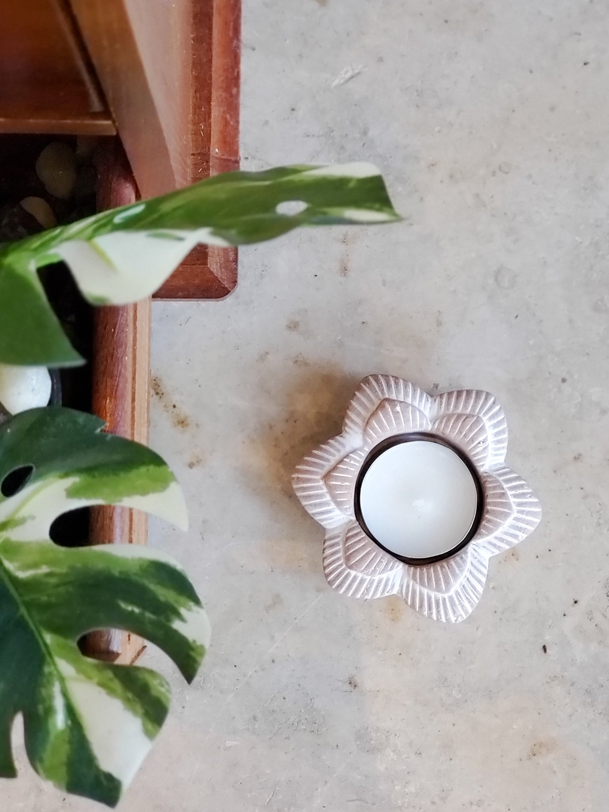 Handmade terracotta tea light candle holder in flower design, showcasing natural clay texture and unique craftsmanship.