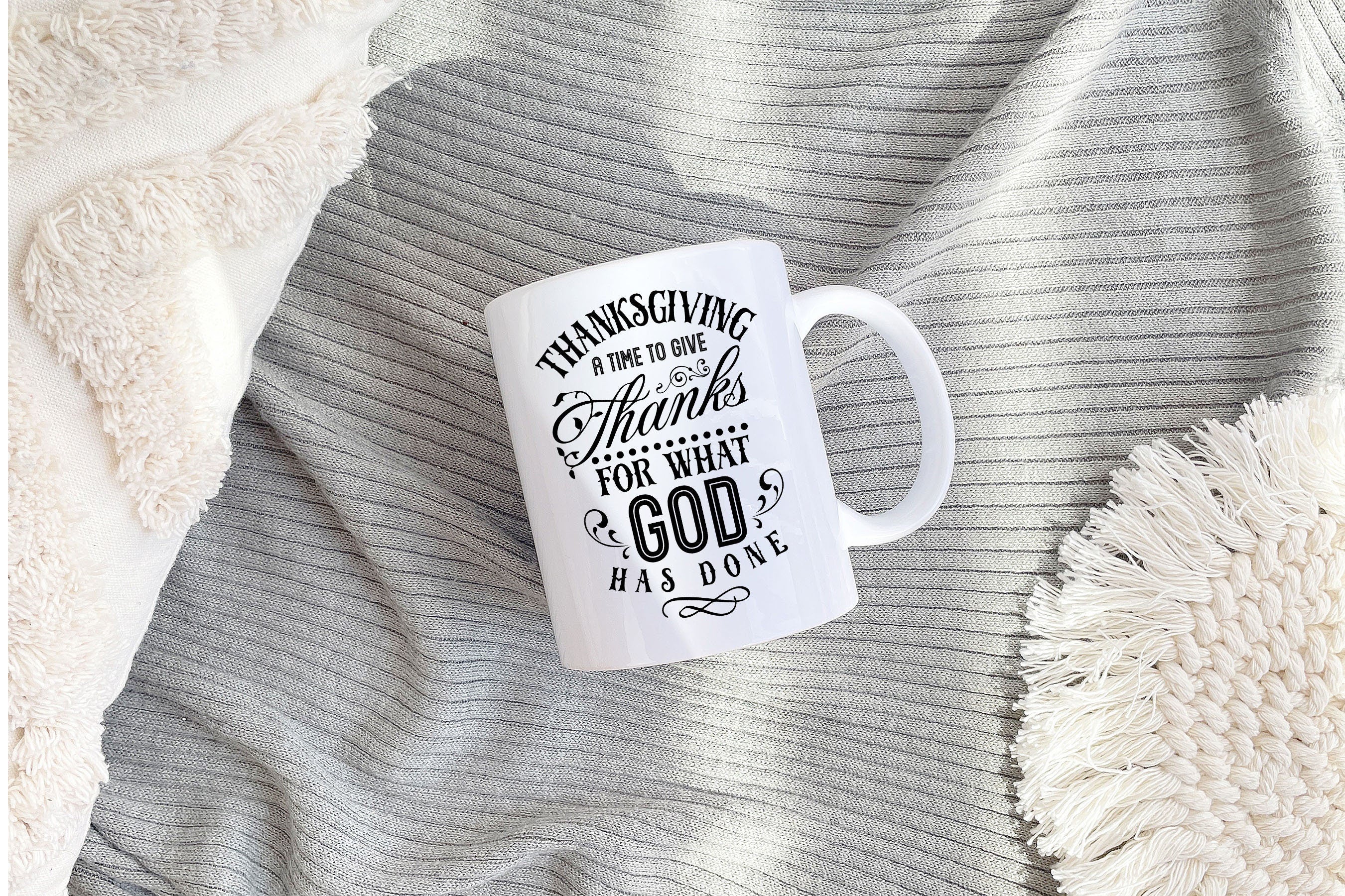 A beautifully designed Thanksgiving mug featuring autumn decor and the phrase 'Give Thanks For What God has Done' printed on both sides.