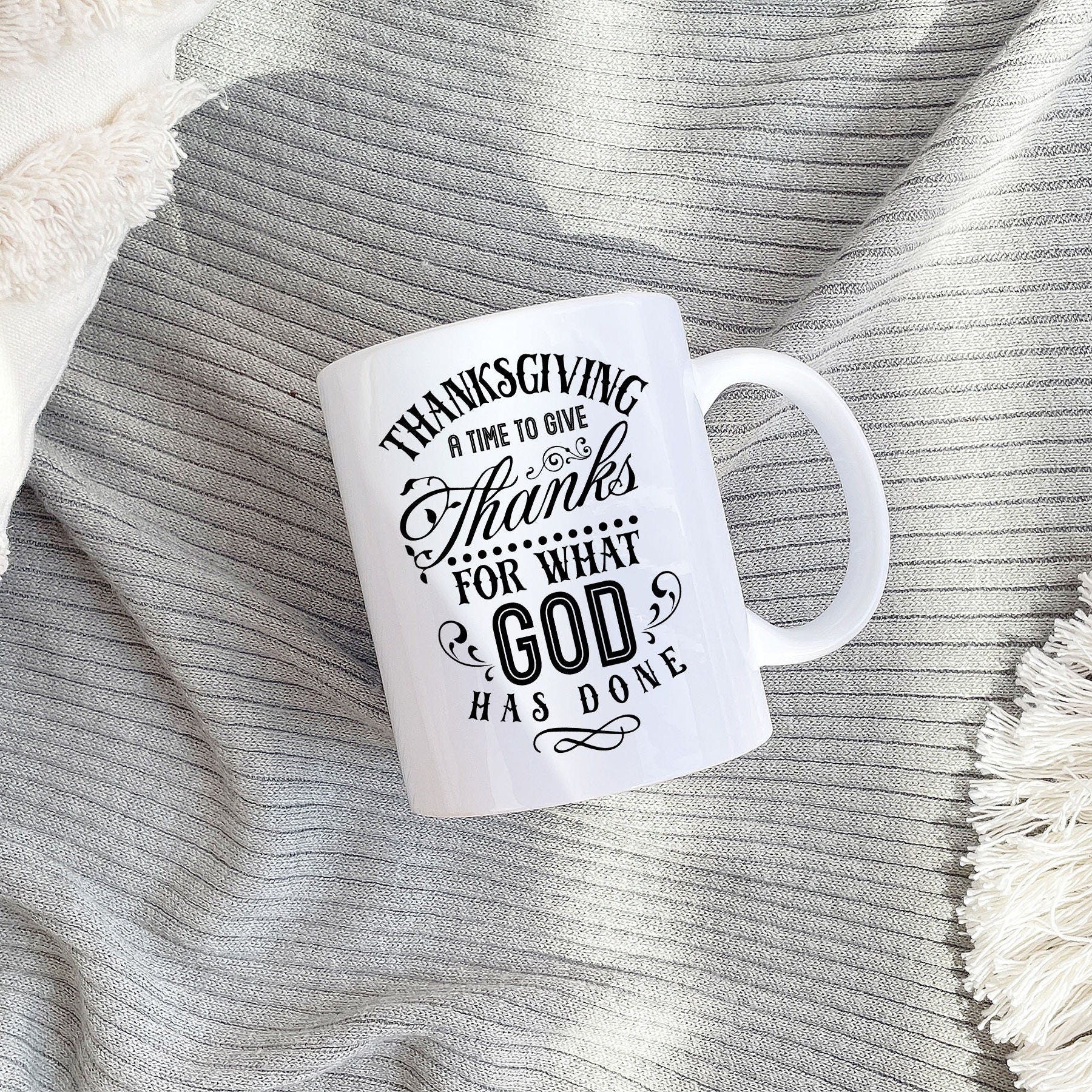 A beautifully designed Thanksgiving mug featuring autumn decor and the phrase 'Give Thanks For What God has Done' printed on both sides.