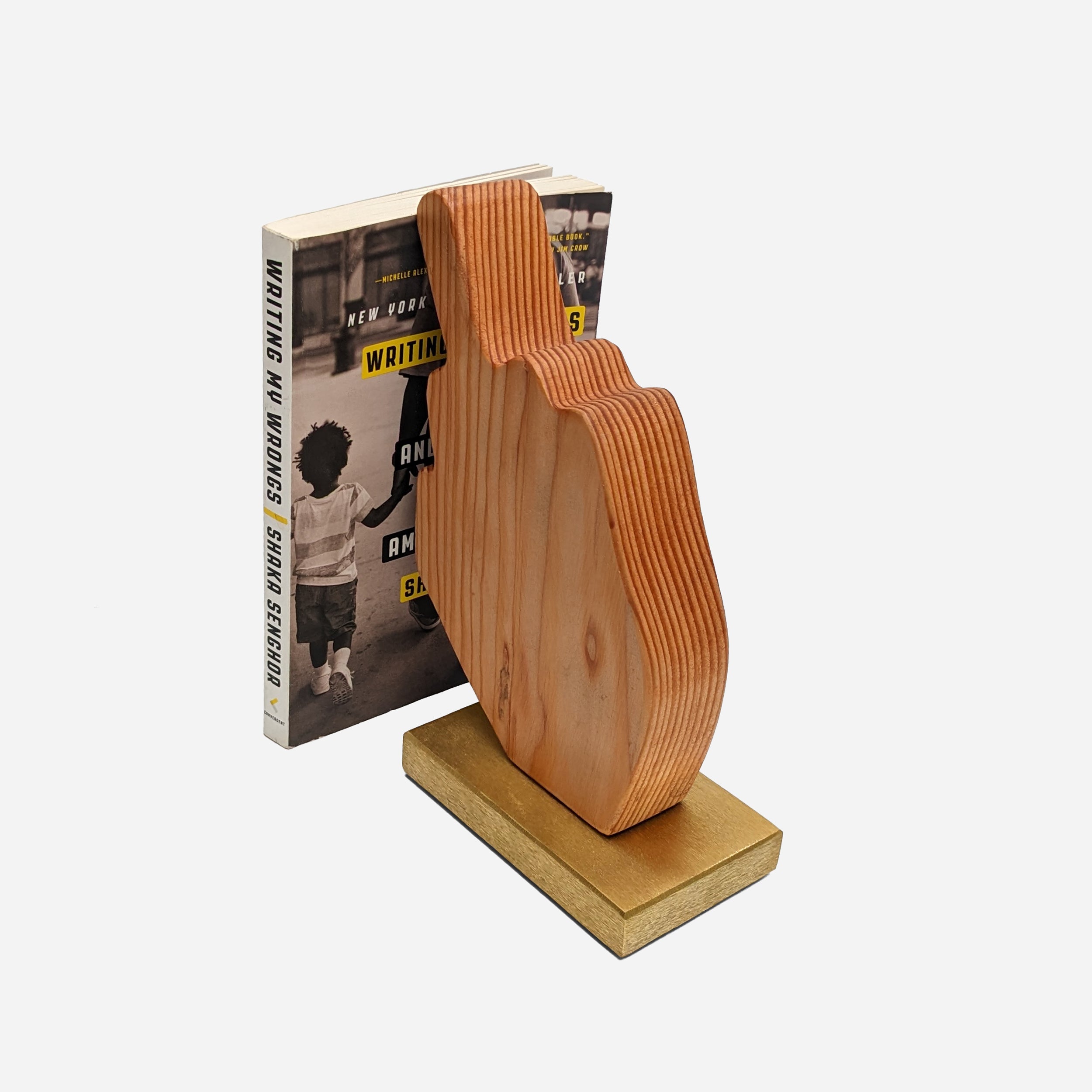 A unique decorative piece called The Finger, made from Doug Fir wood and brass, showcasing its artistic design and craftsmanship.