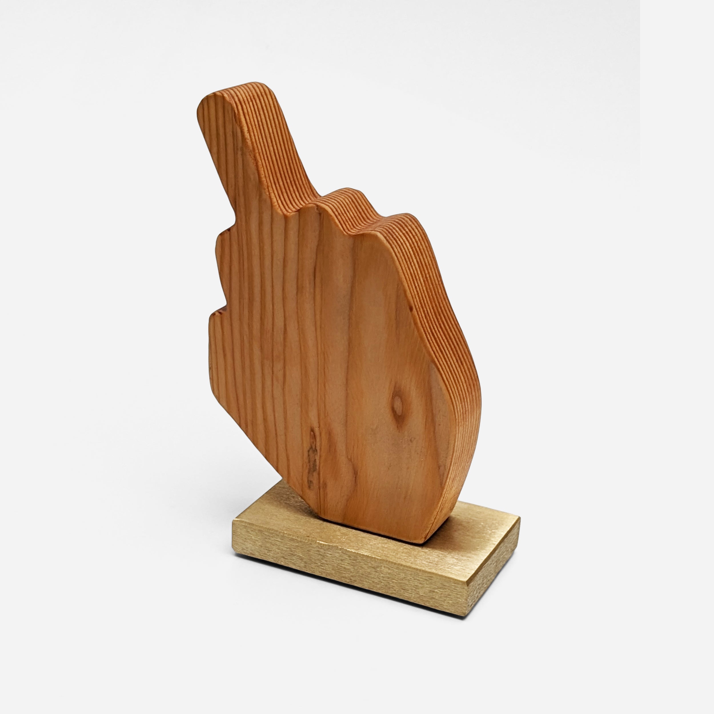 A unique decorative piece called The Finger, made from Doug Fir wood and brass, showcasing its artistic design and craftsmanship.