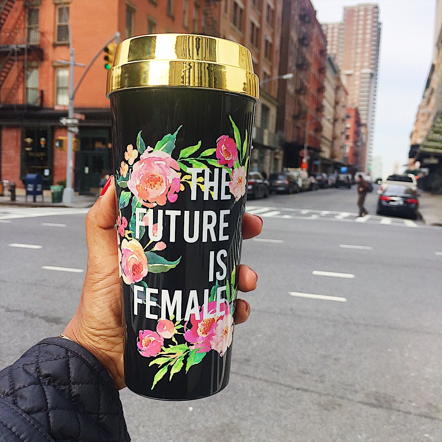 The Future Is Female Travel Mug with a metallic gold lid, showcasing its stylish design and feminist message.