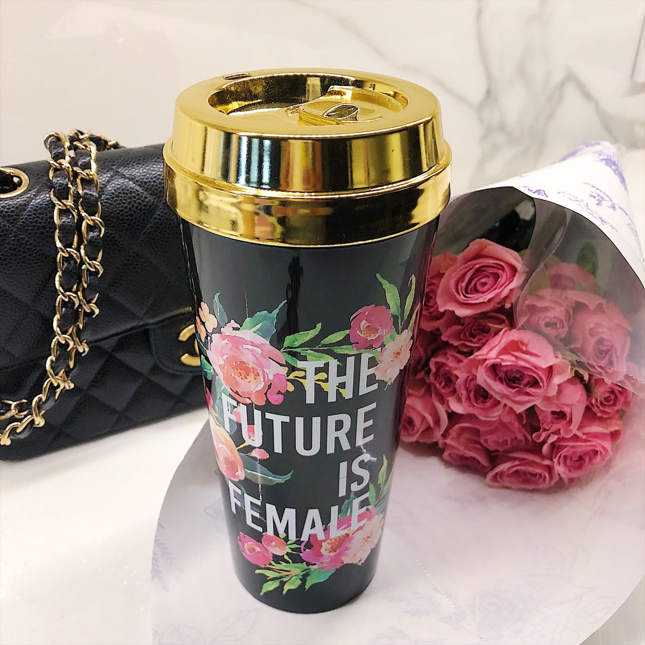 The Future Is Female Travel Mug with a metallic gold lid, showcasing its stylish design and feminist message.