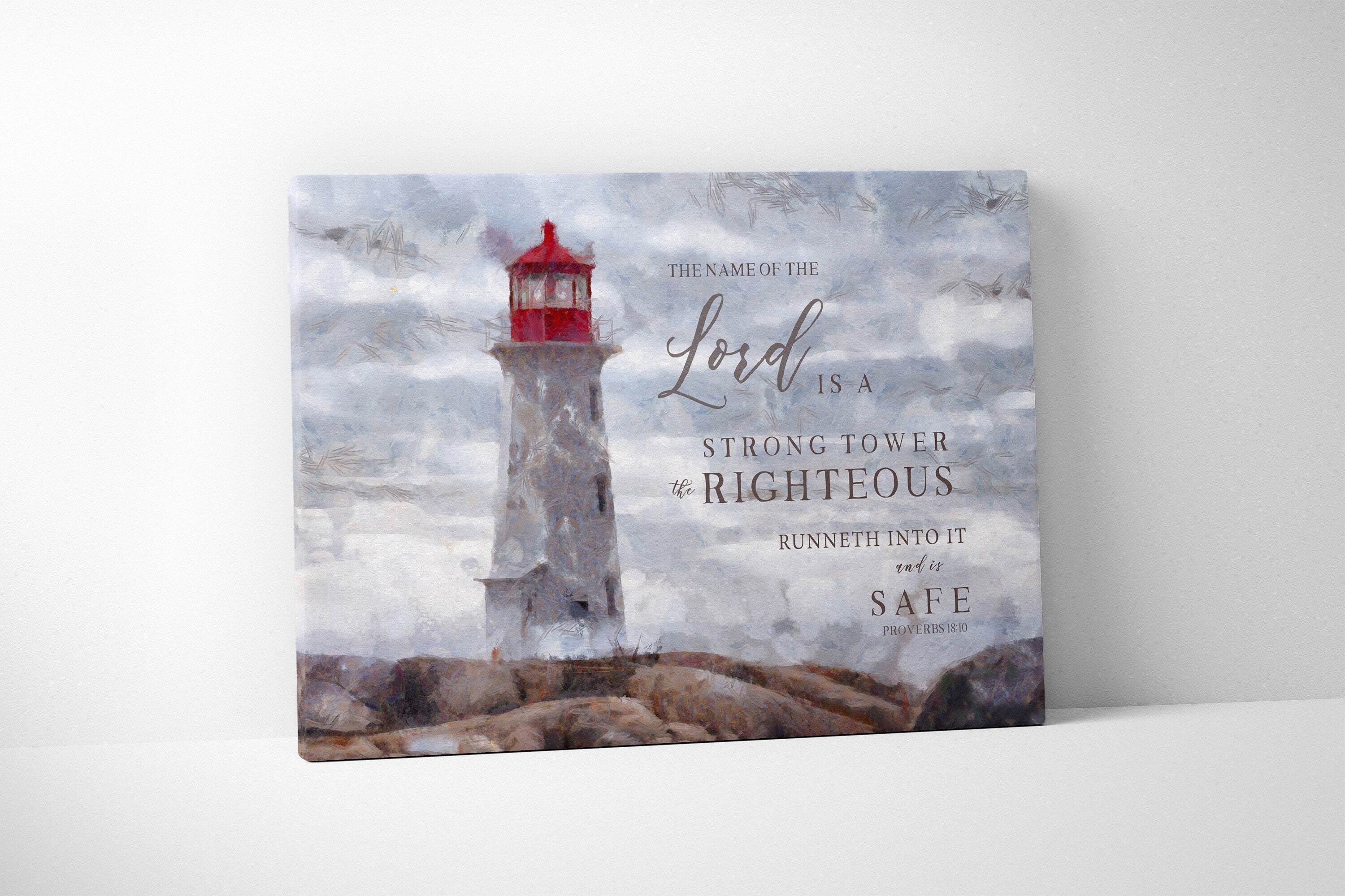 Canvas print featuring a lighthouse and the scripture 'The Name of the Lord is a strong tower' beautifully hand-lettered over a peaceful shore.