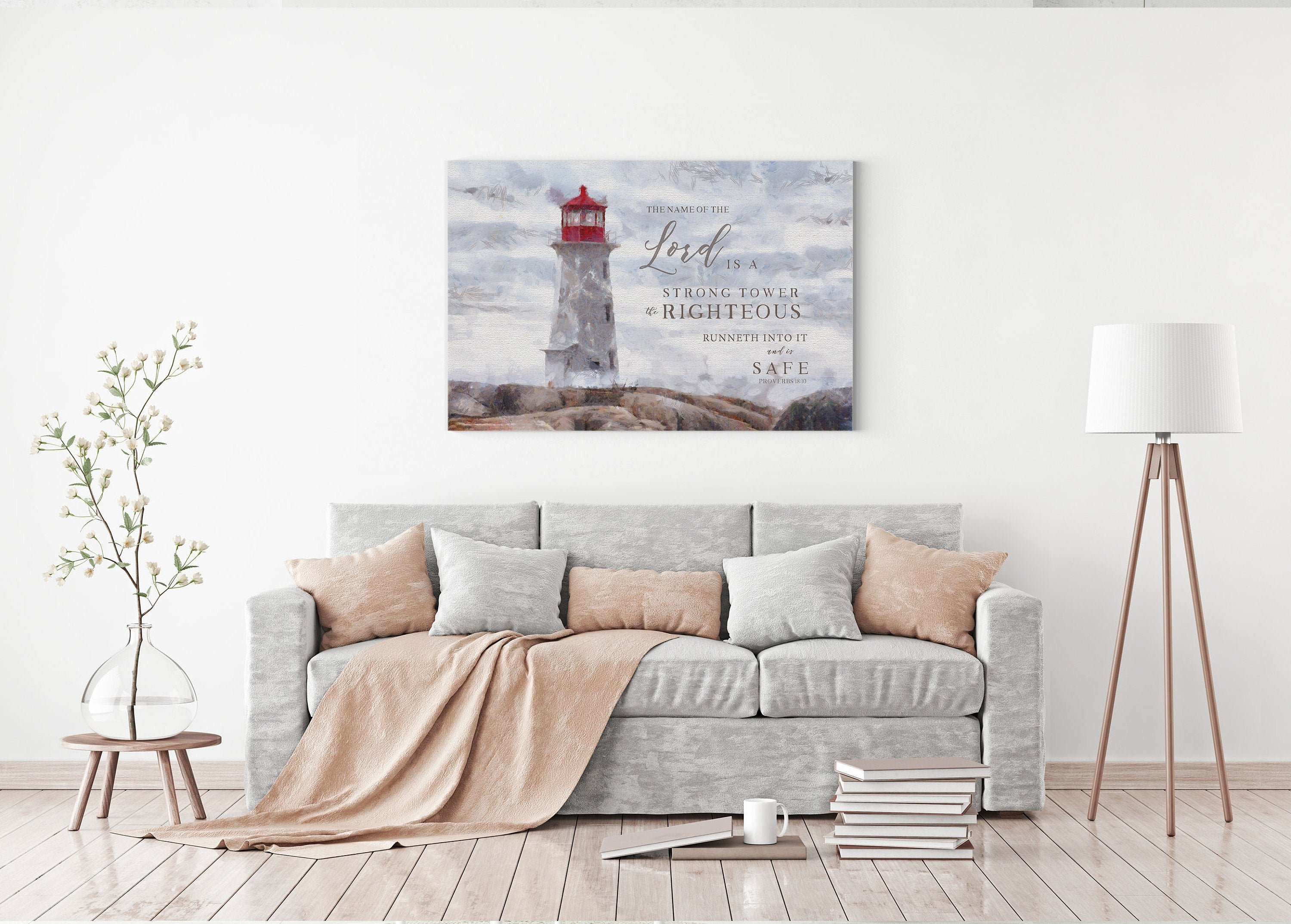 Canvas art featuring a lighthouse with the scripture 'The Name of the Lord is a strong tower' beautifully hand-lettered over a serene shore.