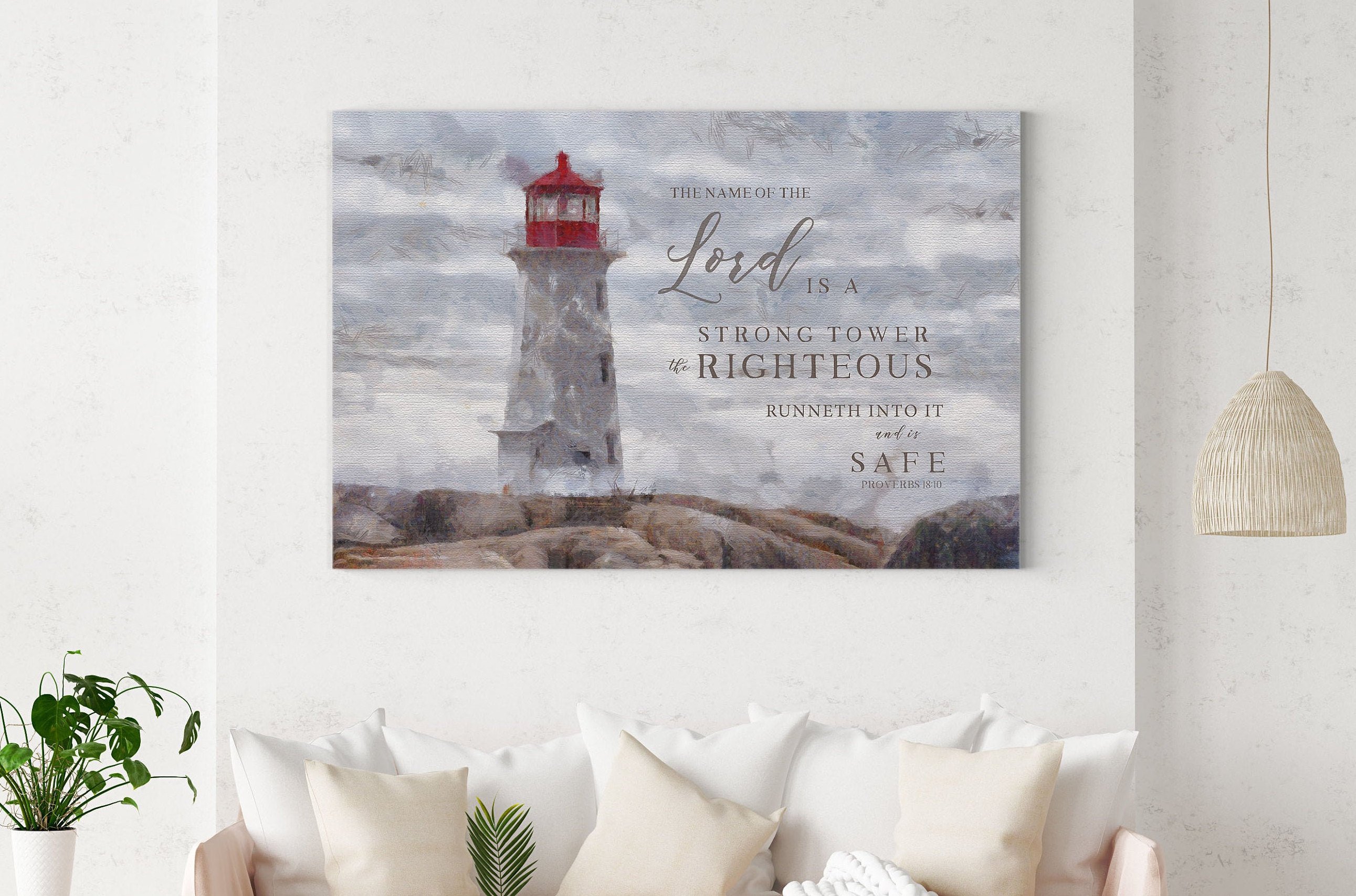 Canvas art featuring a lighthouse with the scripture 'The Name of the Lord is a strong tower' beautifully hand-lettered over a serene shore.