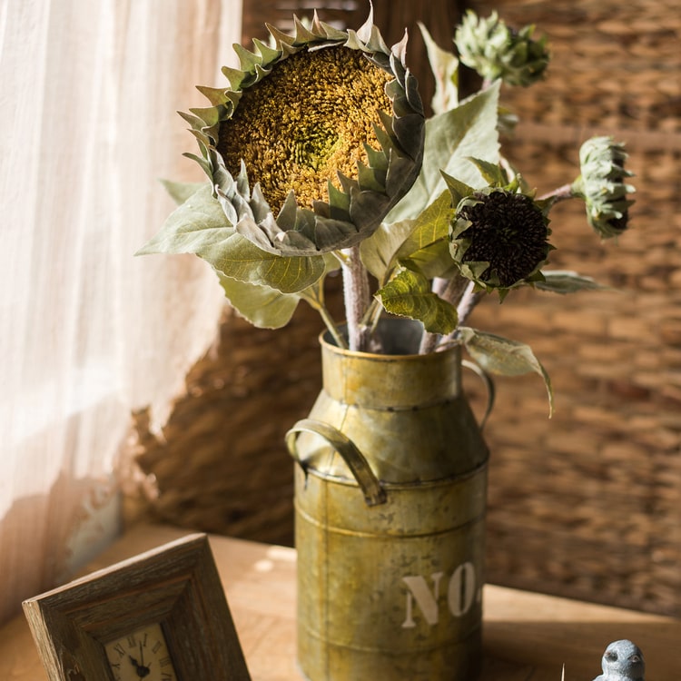 A beautiful handmade artificial sunflower stem with vibrant yellow petals, green leaves, and a brown stem, perfect for home decor.