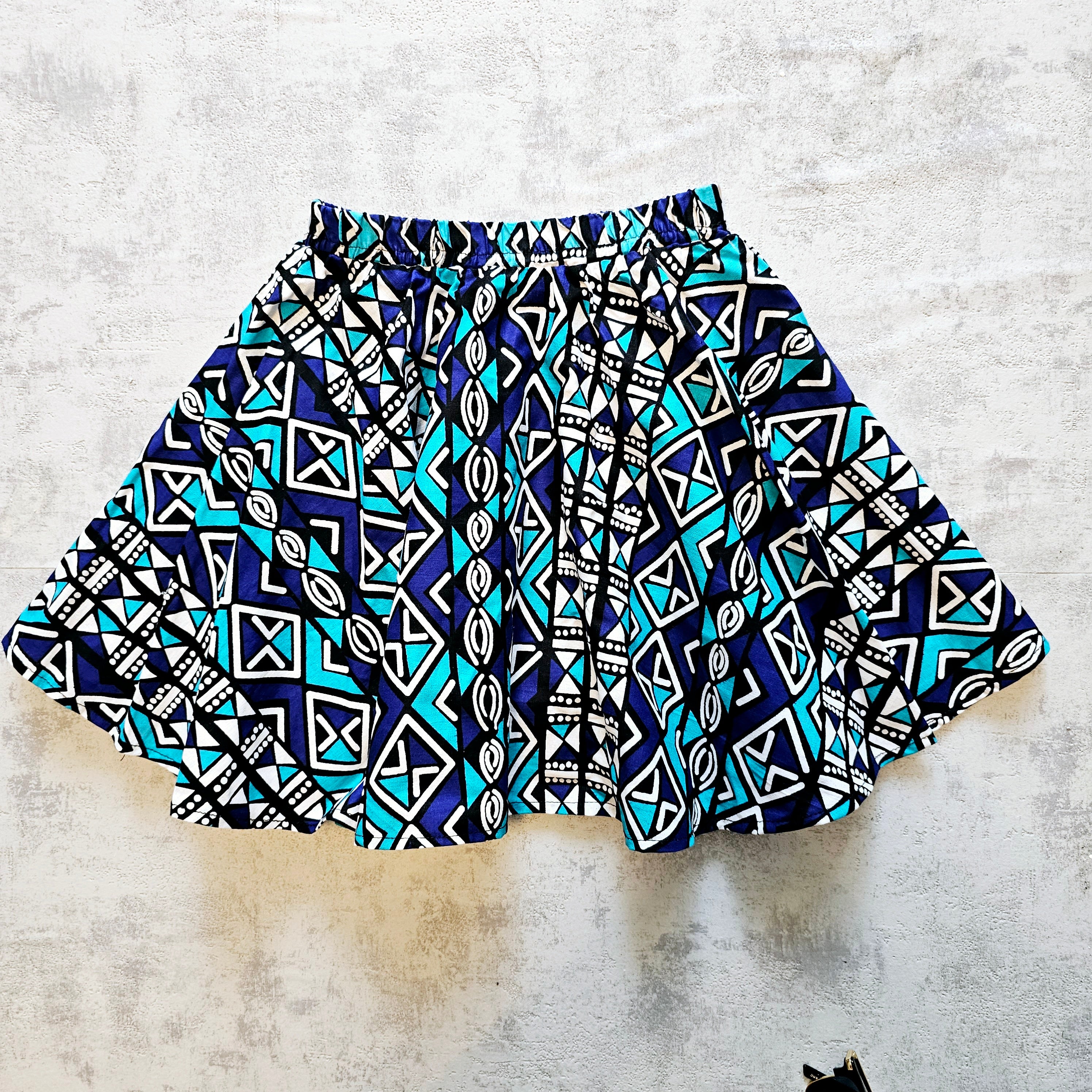 A vibrant toddler circle skirt made from Ankara fabric, featuring a colorful design and an elastic waistband, perfect for playful little girls.