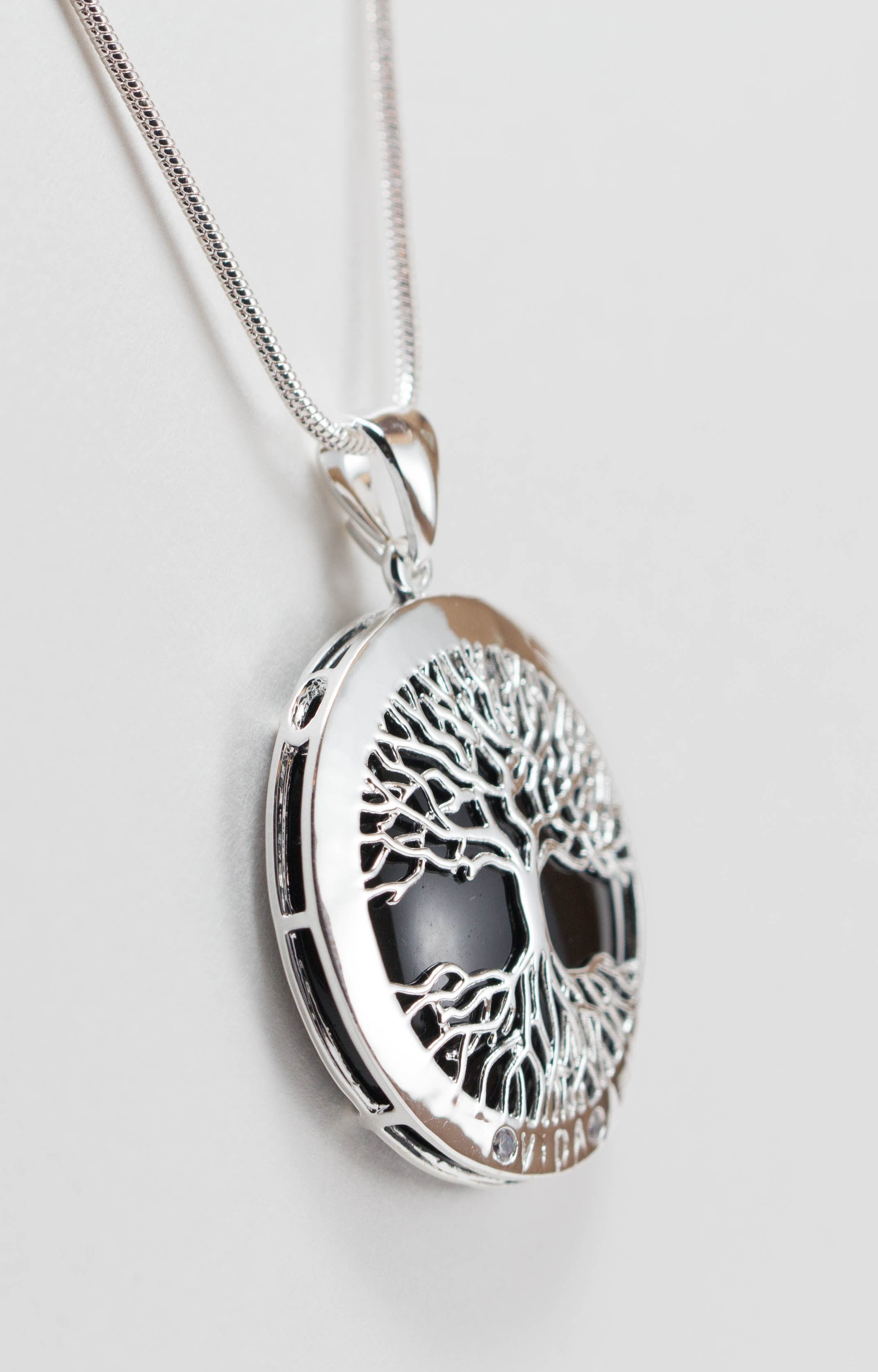 A beautiful Tree of Life Necklace featuring an intricate pendant on a silver chain, symbolizing growth and connection.