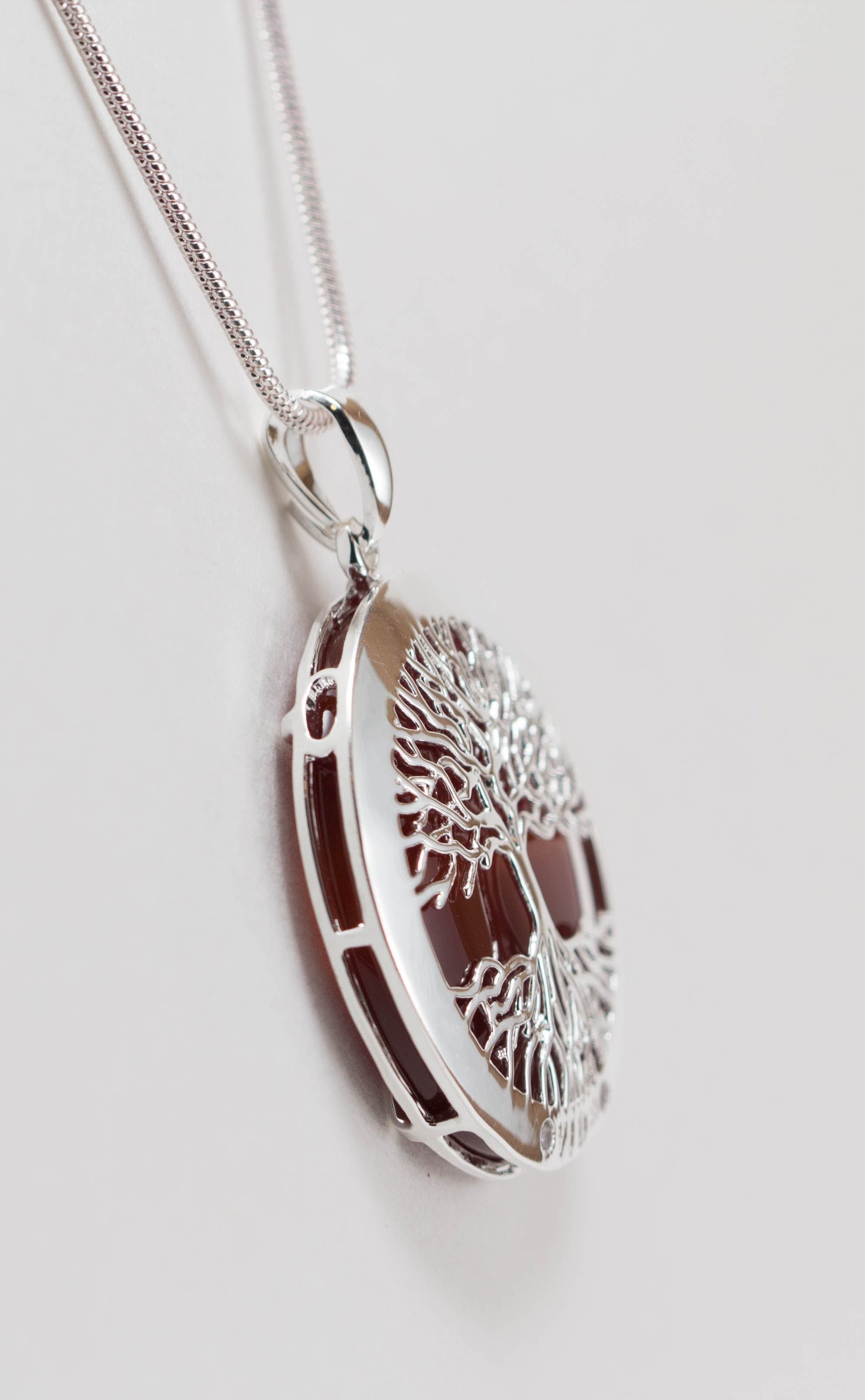 A beautiful Tree of Life Necklace featuring an intricate pendant on a silver chain, symbolizing growth and connection.