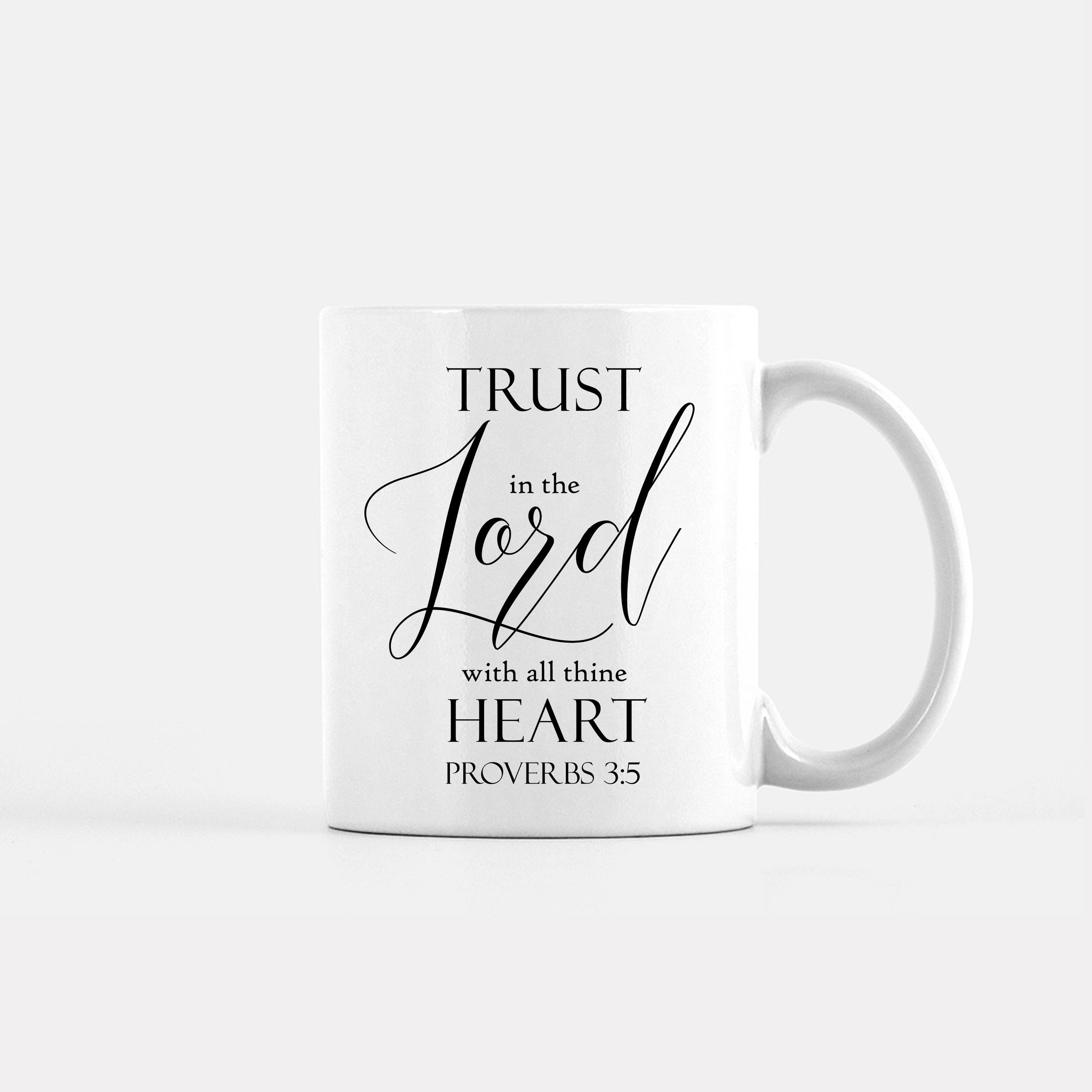 A ceramic mug featuring the quote 'Trust In The Lord With All Thine Heart' printed on both sides, available in two sizes.