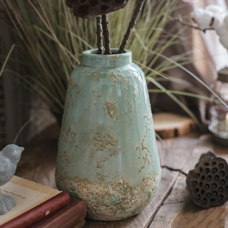 A beautifully handcrafted turquoise ceramic vase with a textured finish, showcasing unique color variations.