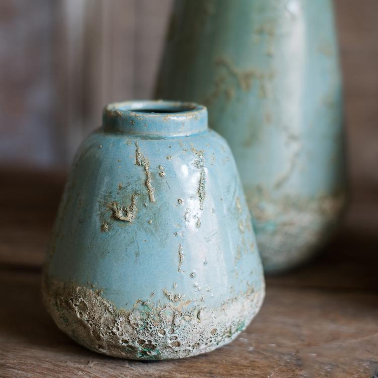 A beautifully handcrafted turquoise ceramic vase with a textured finish, showcasing unique color variations.