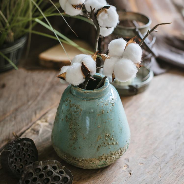 A beautifully handcrafted turquoise ceramic vase with a textured finish, showcasing unique color variations.