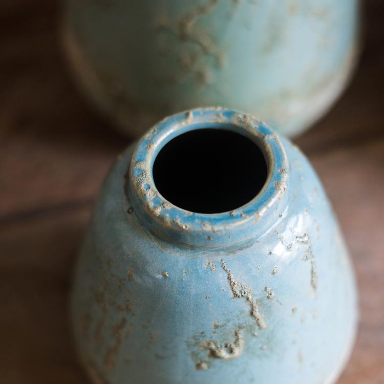 A beautifully handcrafted turquoise ceramic vase with a textured finish, showcasing unique color variations.