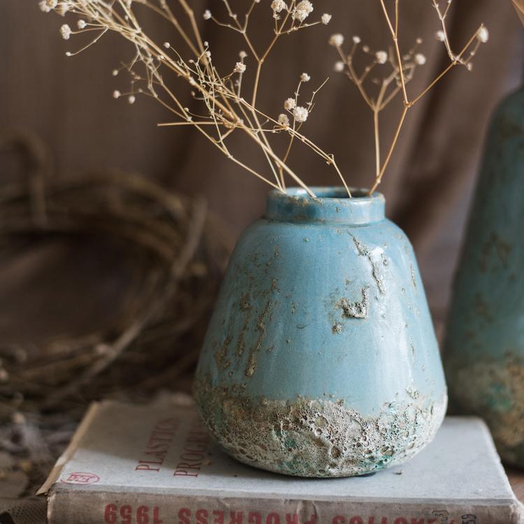 A beautifully handcrafted turquoise ceramic vase with a textured finish, showcasing unique color variations.