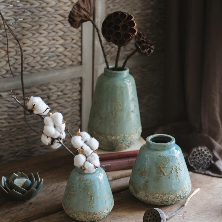 A beautifully handcrafted turquoise ceramic vase with a textured finish, showcasing unique color variations.