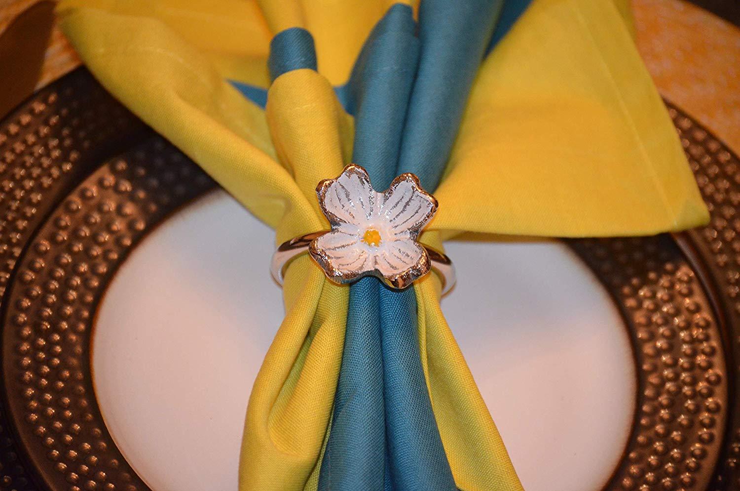 Set of 4 handcrafted silver floral napkin rings made from aluminum, featuring intricate flower designs for elegant table settings.