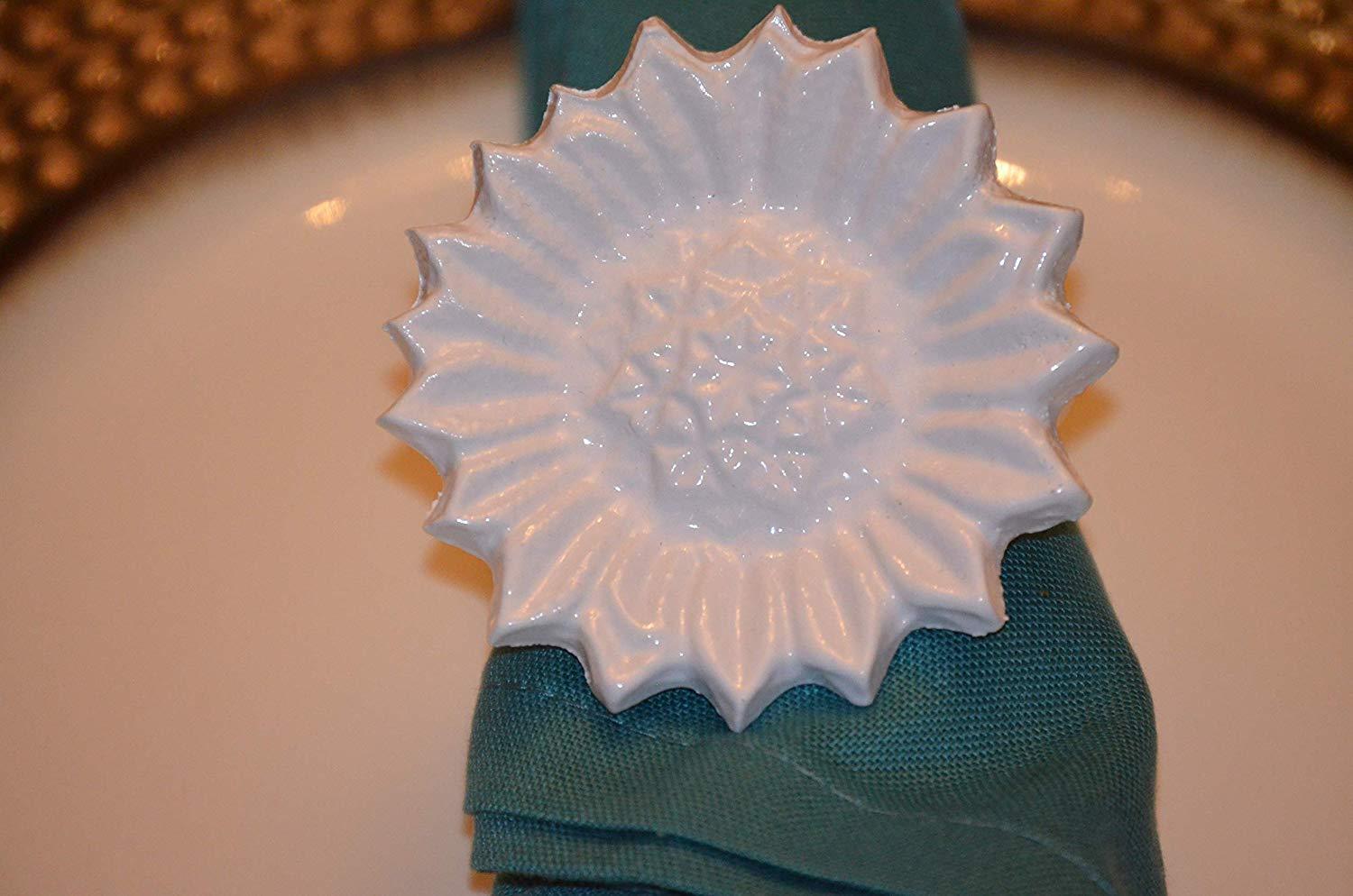 Set of 4 handcrafted white aluminum sunflower napkin rings, elegantly designed for dining decor.