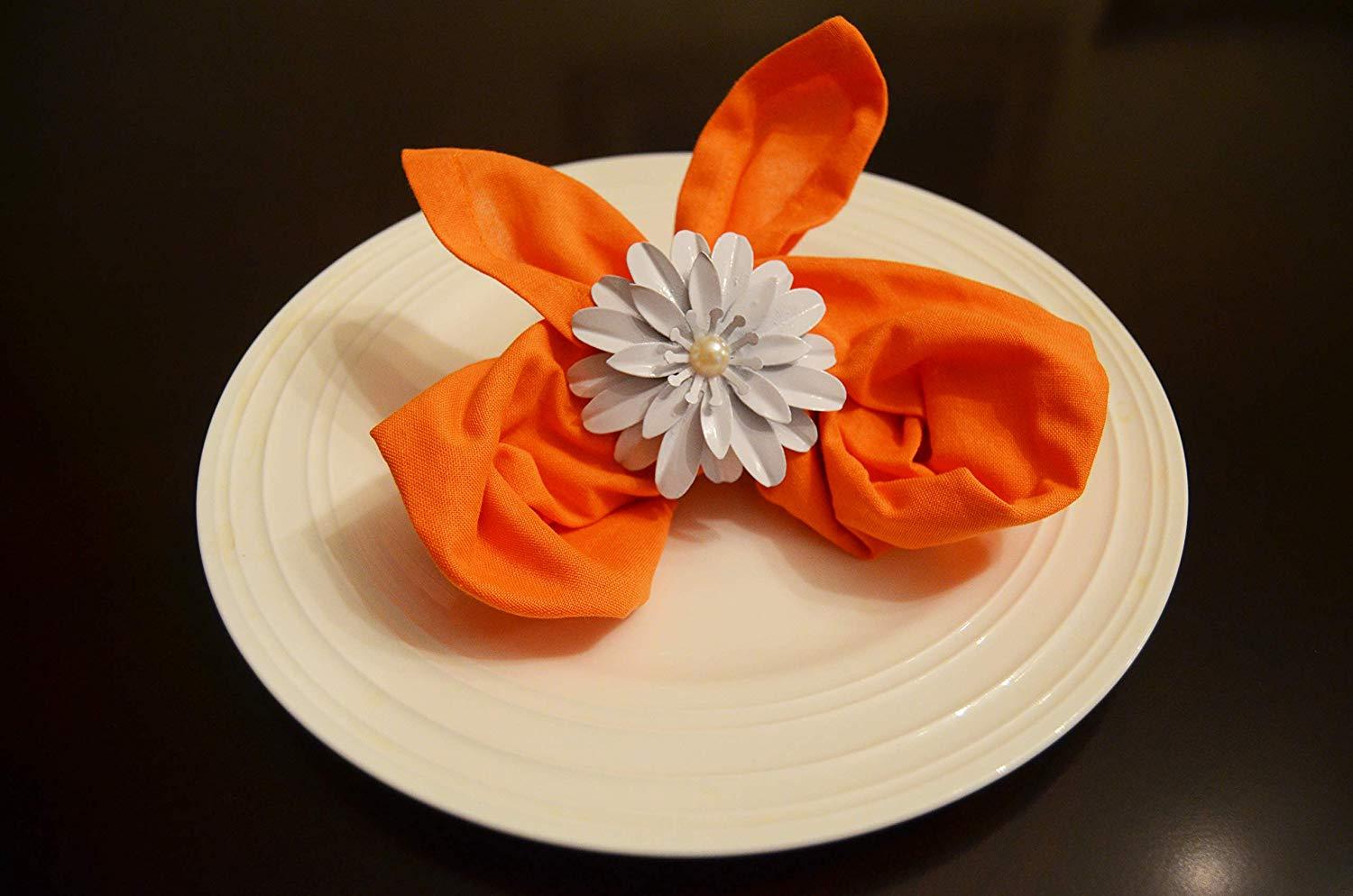 Vibhsa White Floral Set of 4 Napkin Rings featuring handcrafted white flowers and pearls, elegantly displayed on a dining table.