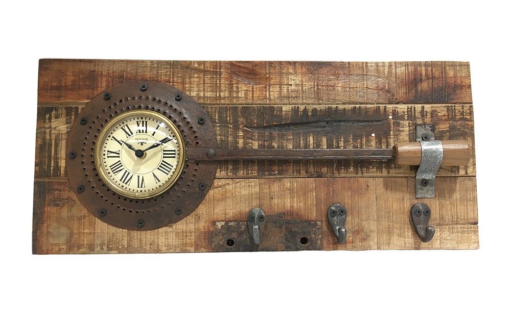 A decorative wall clock featuring an old iron frying pan mounted on a recycled mango wood board, showcasing a rustic and antique finish.