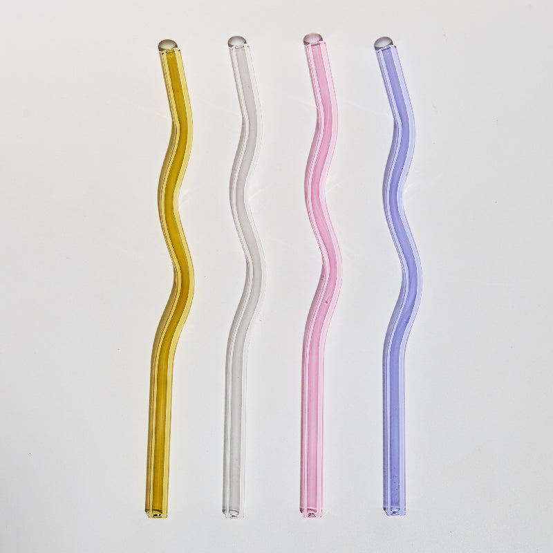 A set of elegant wavy glass straws in various colors, showcasing their unique curved design and included cleaning brush.