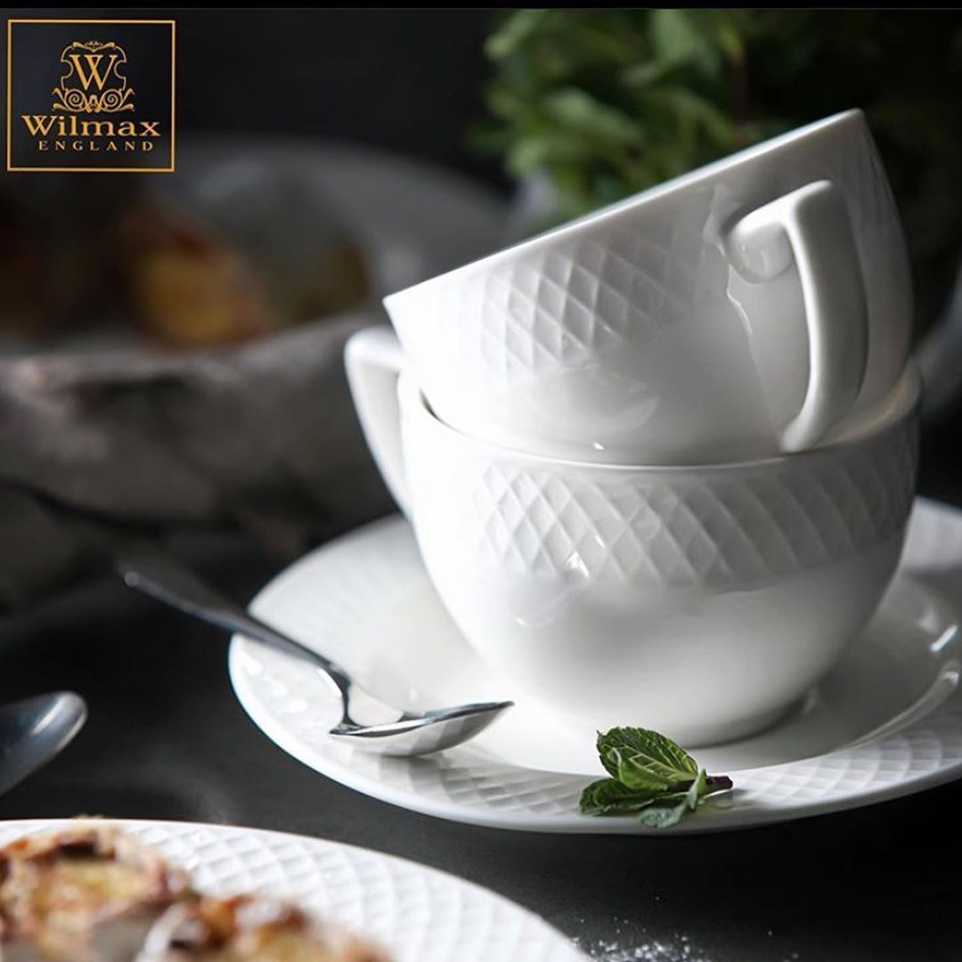 A set of six white porcelain coffee cups and saucers elegantly displayed in a gift box, showcasing their embossed design and rolled rim.