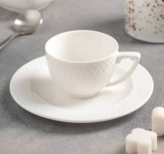 A set of six white porcelain coffee cups and saucers elegantly displayed in a gift box, showcasing their embossed design and rolled rim.