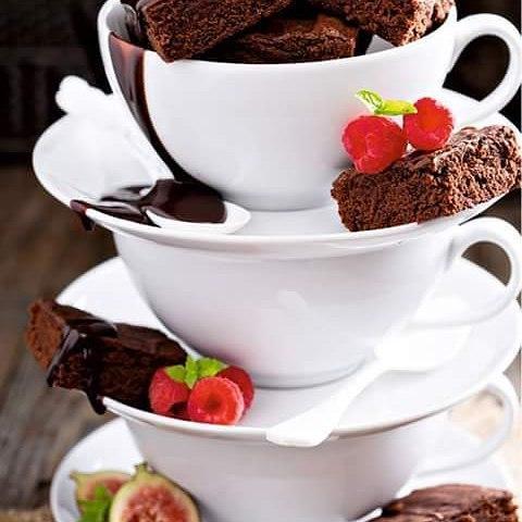 A set of six white porcelain coffee cups and saucers elegantly displayed in a gift box, showcasing their embossed design and rolled rim.