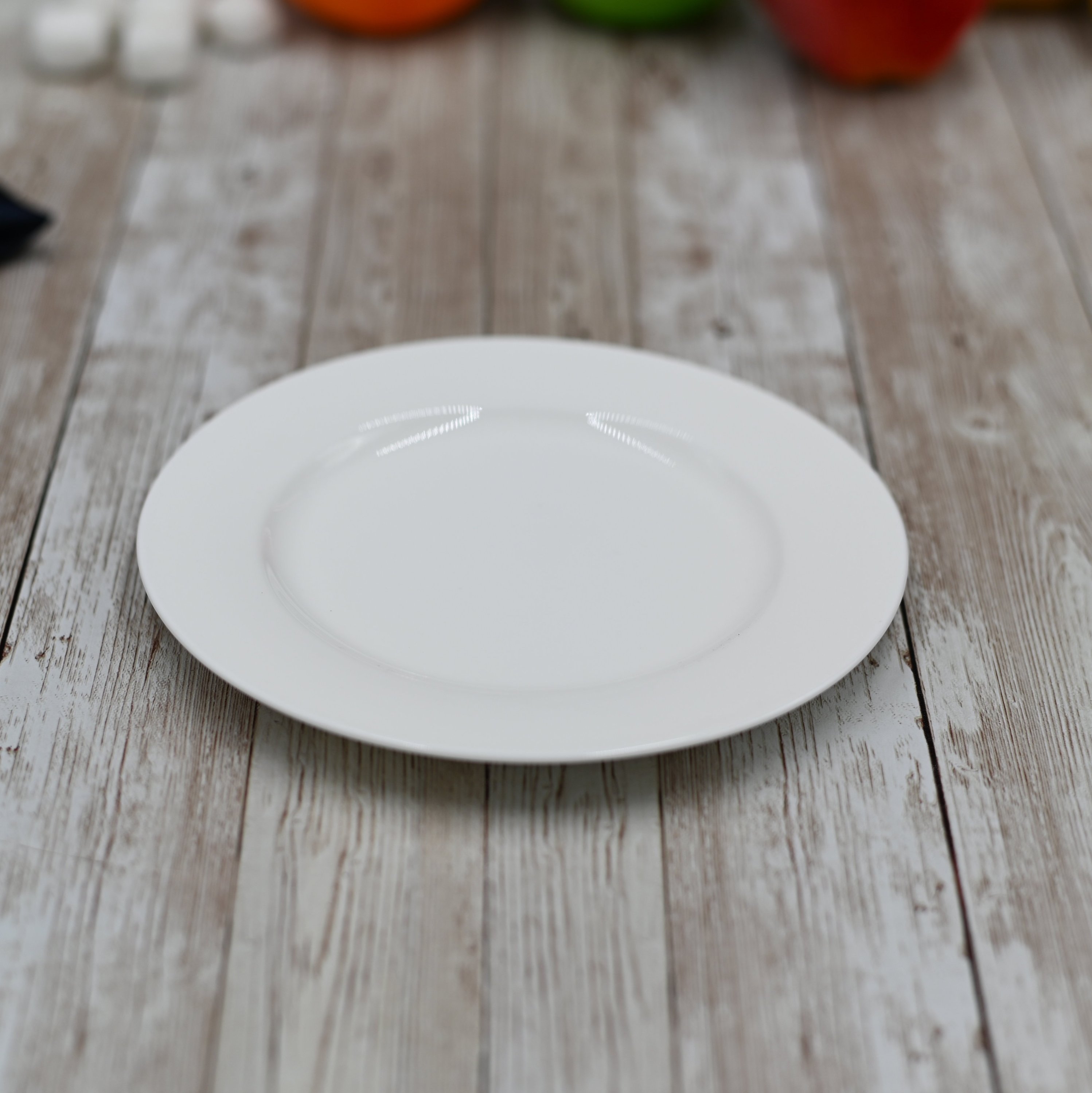 A 6-inch white porcelain bread plate with a rolled rim, showcasing its elegant design and smooth finish.