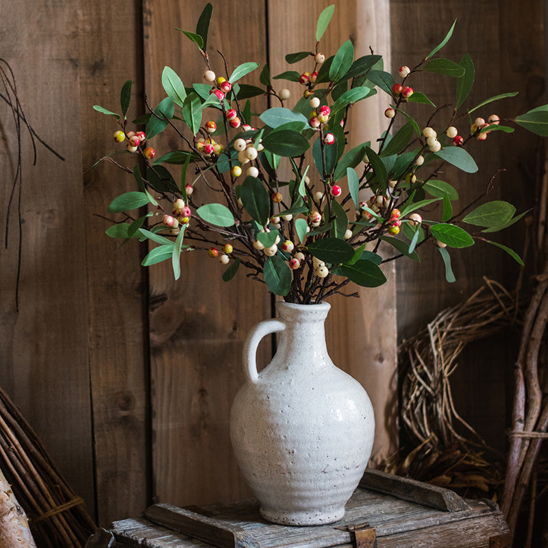 A beautifully crafted white ceramic vase with a small opening, showcasing a textured finish and unique handmade details.