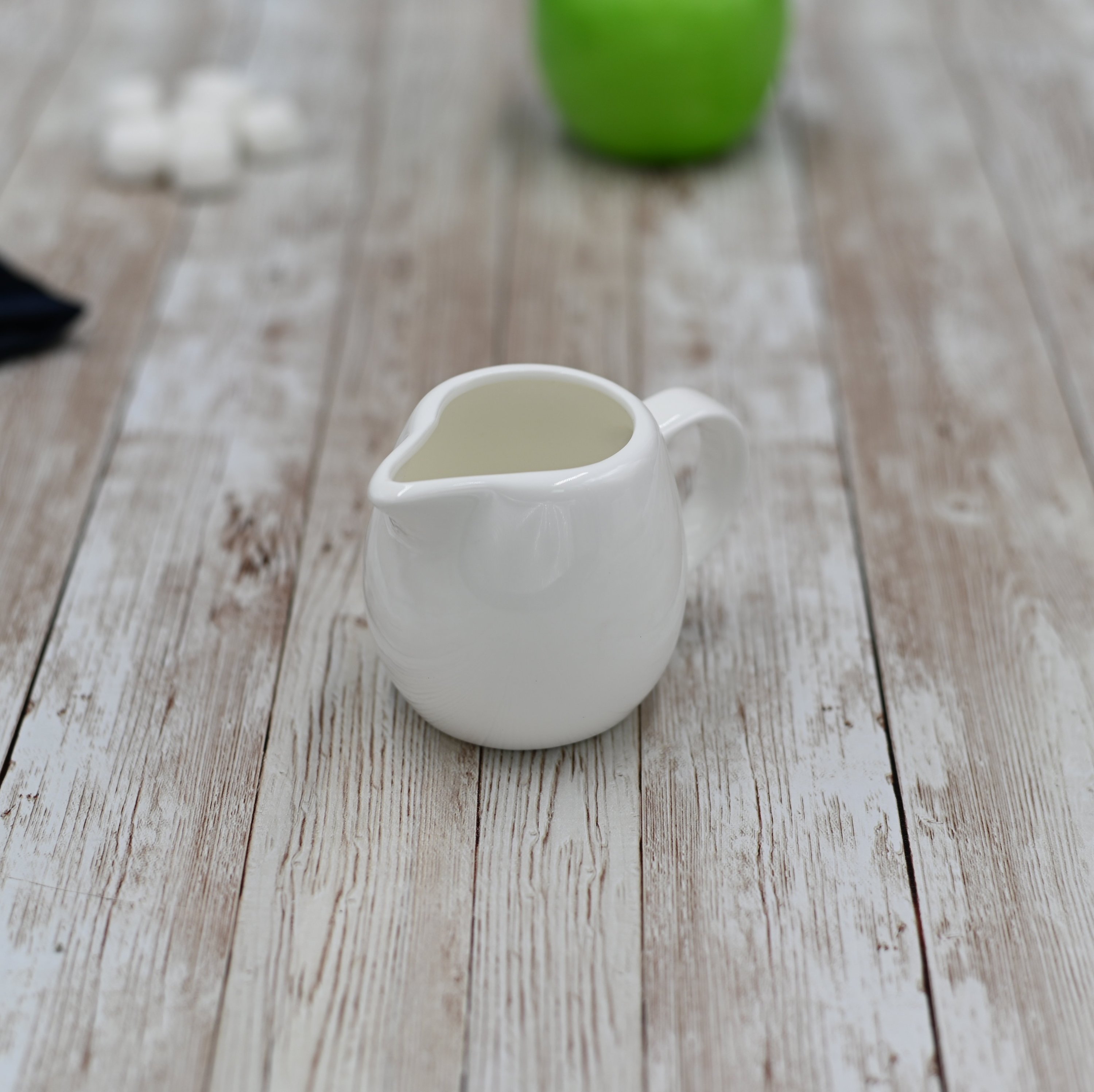 Wilmax White Creamer 5 oz, elegantly designed porcelain creamer with a handle, perfect for serving cream or sauces.