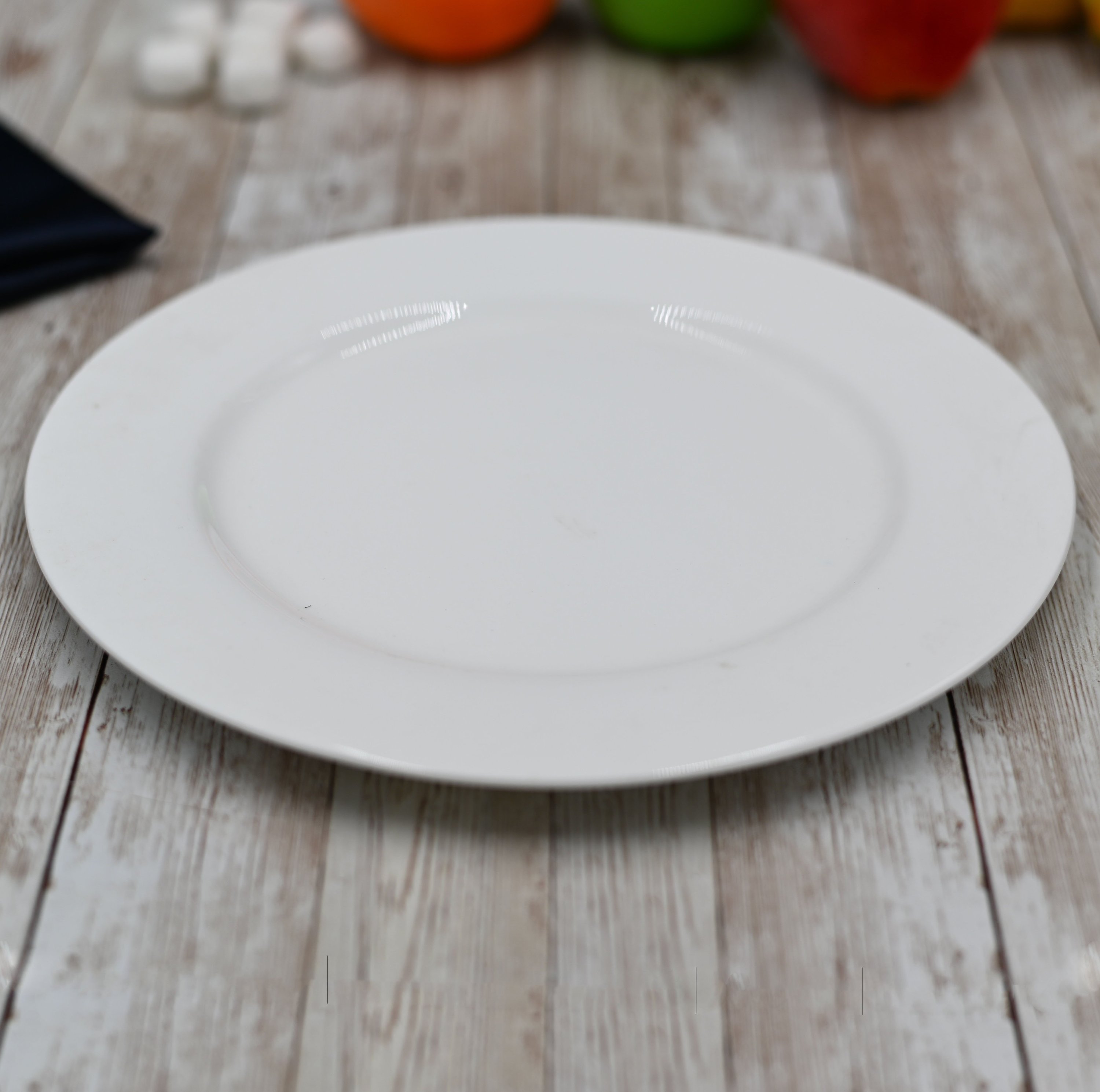 A set of elegant 10-inch white dinner plates made from fine porcelain, showcasing a smooth surface and rolled rim design.