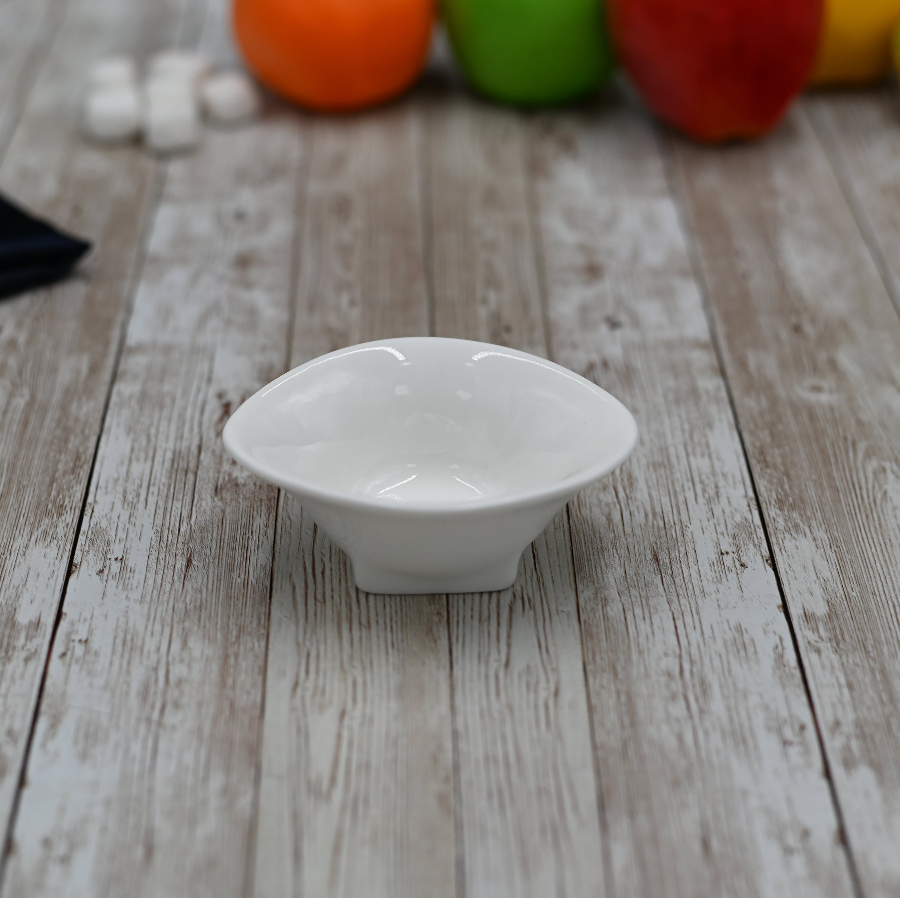 A stylish 4-inch white serving dish with an angled round shape and rolled rim, made from fine vitrified porcelain.