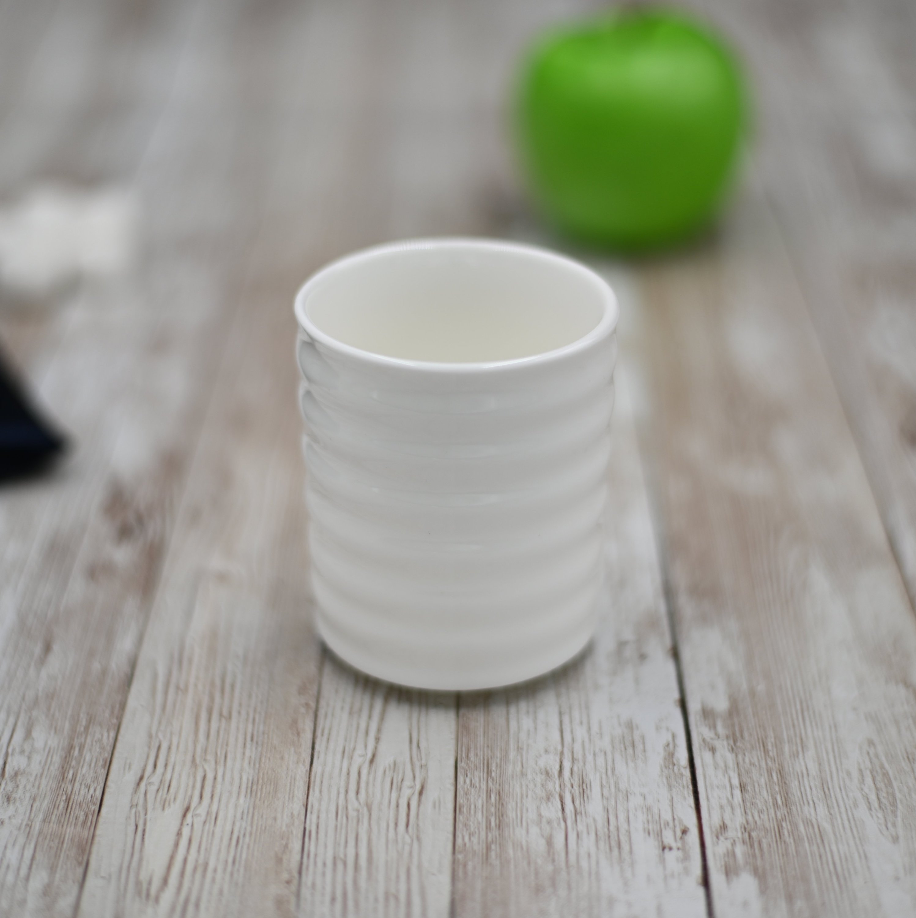 Elegant white Japanese style cup, 7 oz capacity, showcasing a sleek round shape and cascading wave texture, perfect for serving beverages.