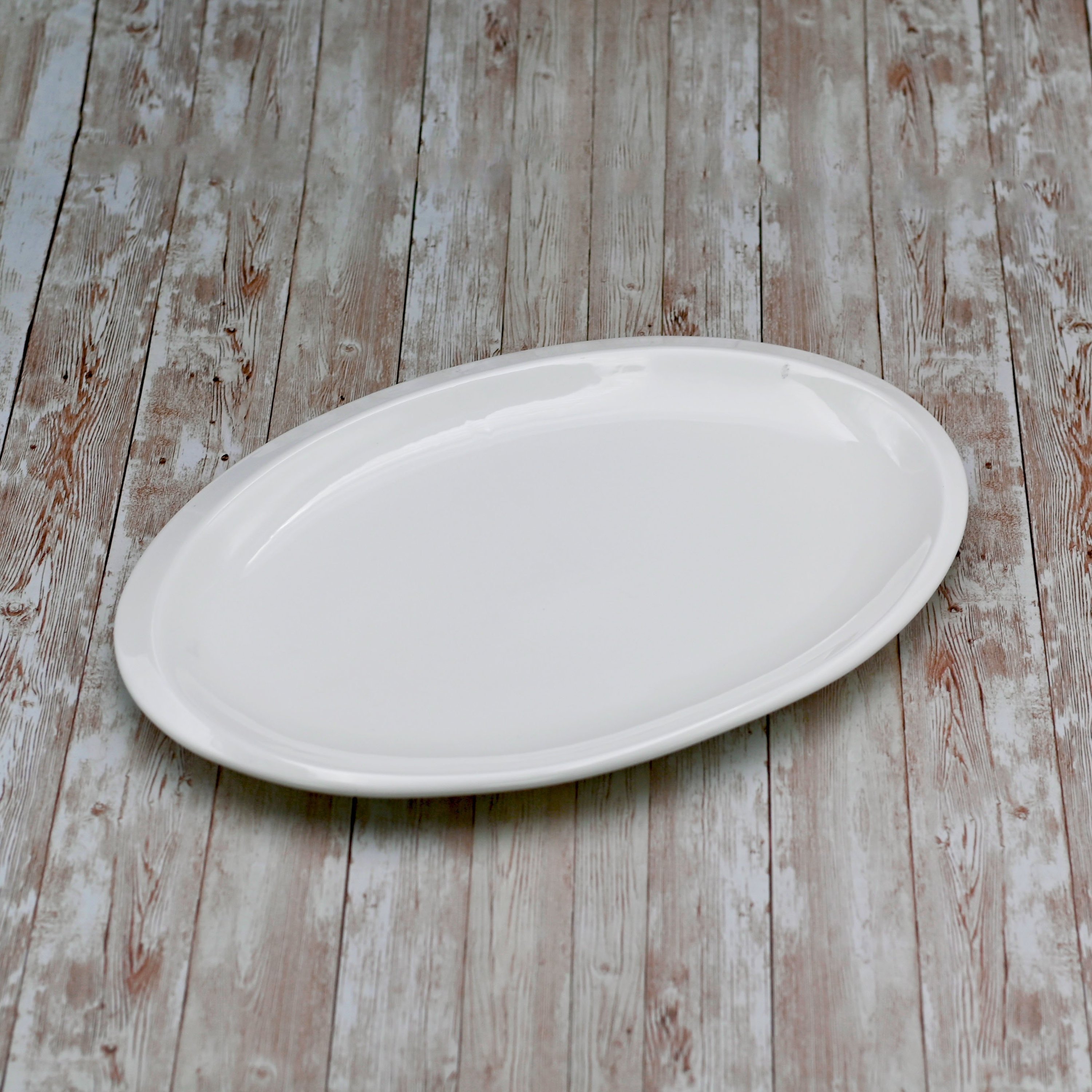 Elegant white oval platter measuring 12 inches, perfect for serving various dishes.