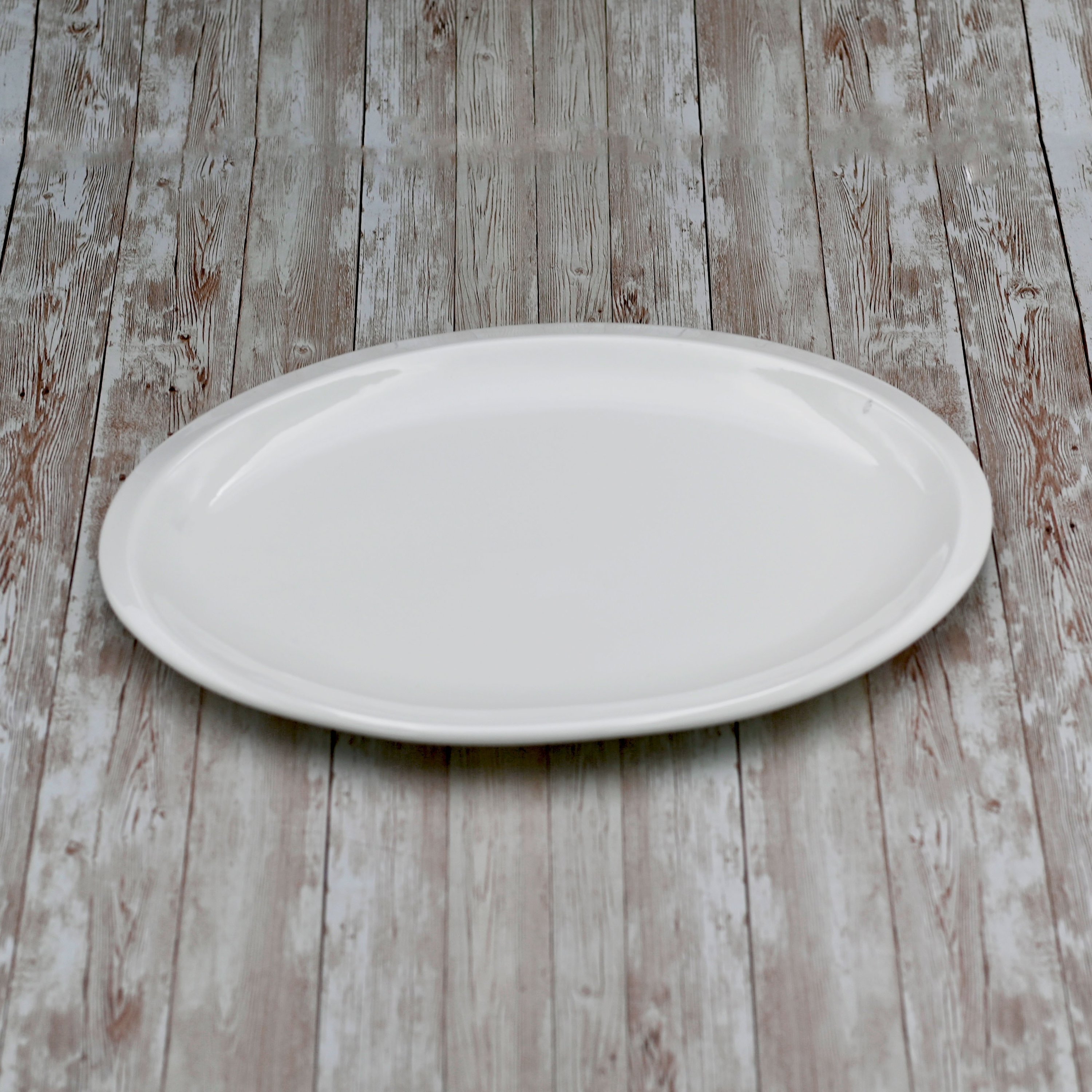 Elegant white oval platter measuring 14 inches, perfect for serving various dishes, made from high-quality porcelain.