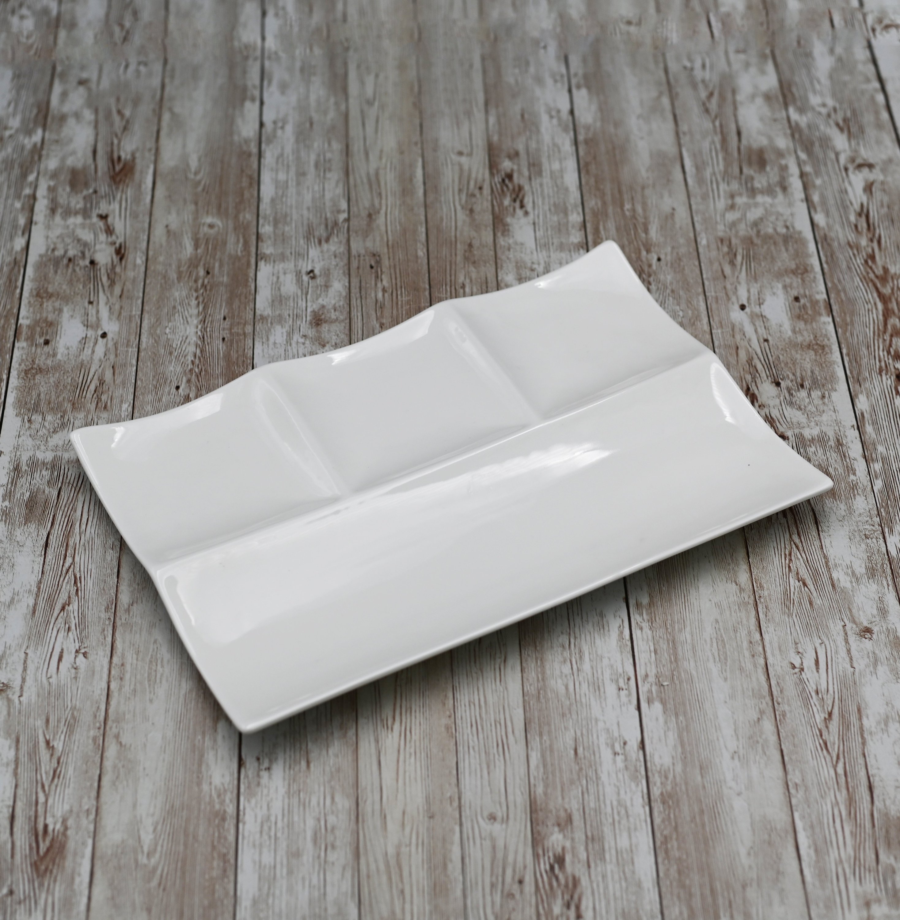 Elegant white porcelain divided platter with four compartments, measuring 12 inches by 8 inches, perfect for serving various dishes.