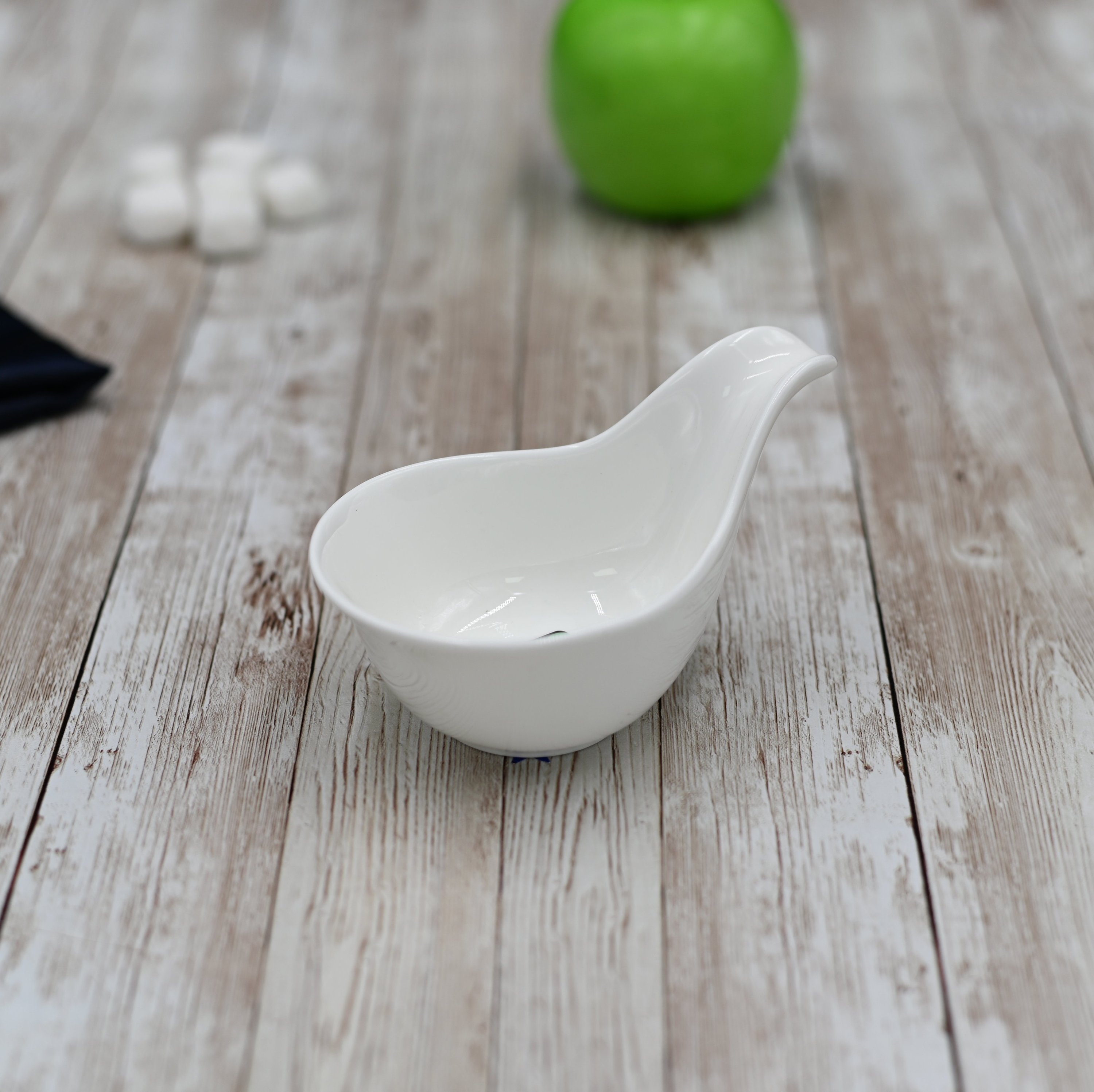 Elegant white porcelain snack dish with handle, perfect for appetizers and desserts.