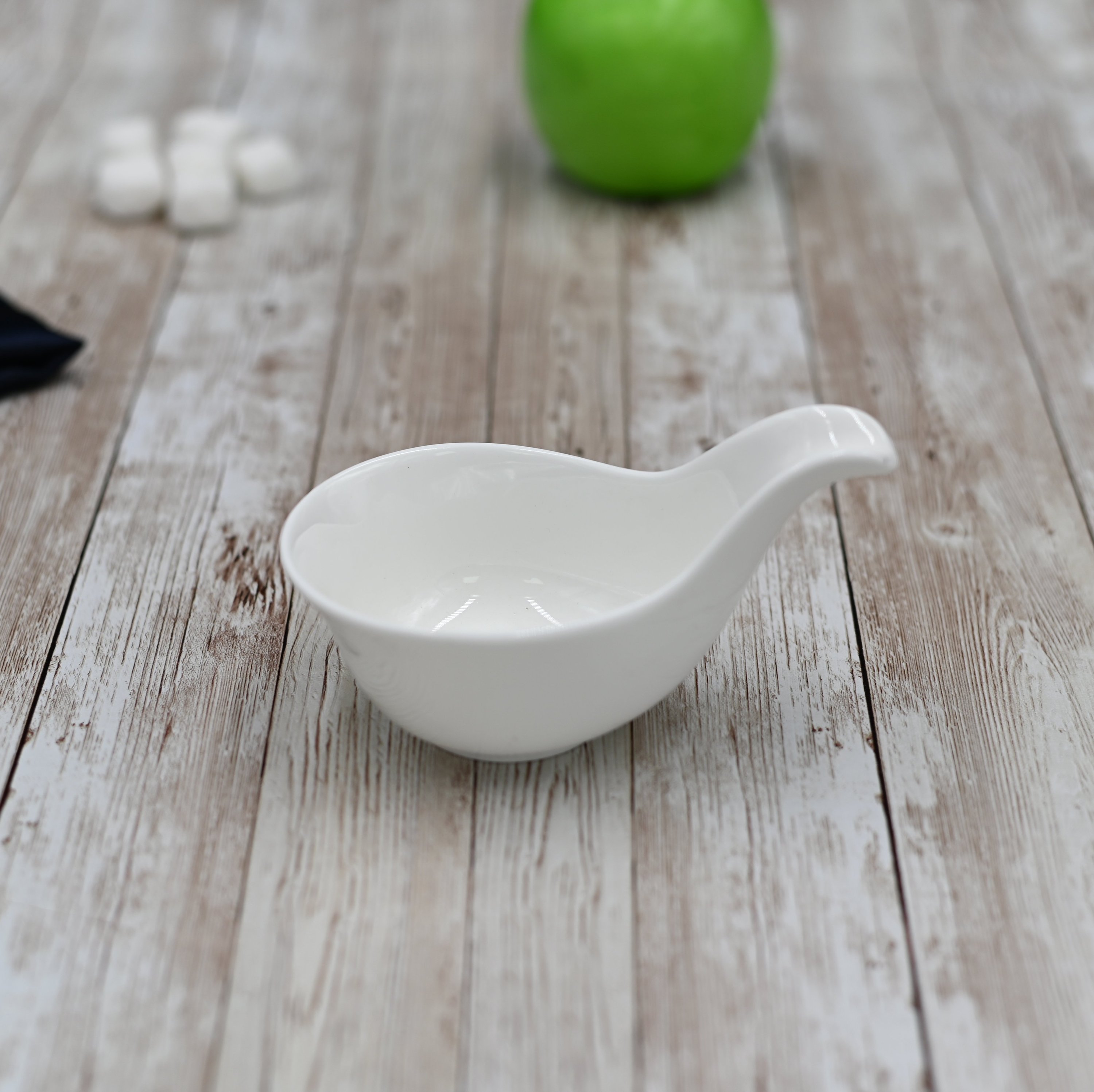 Elegant white porcelain snack dish with handle, perfect for appetizers and desserts.