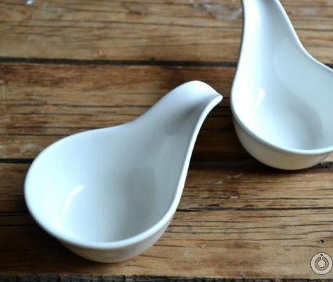 Elegant white porcelain snack dish with handle, perfect for appetizers and desserts.