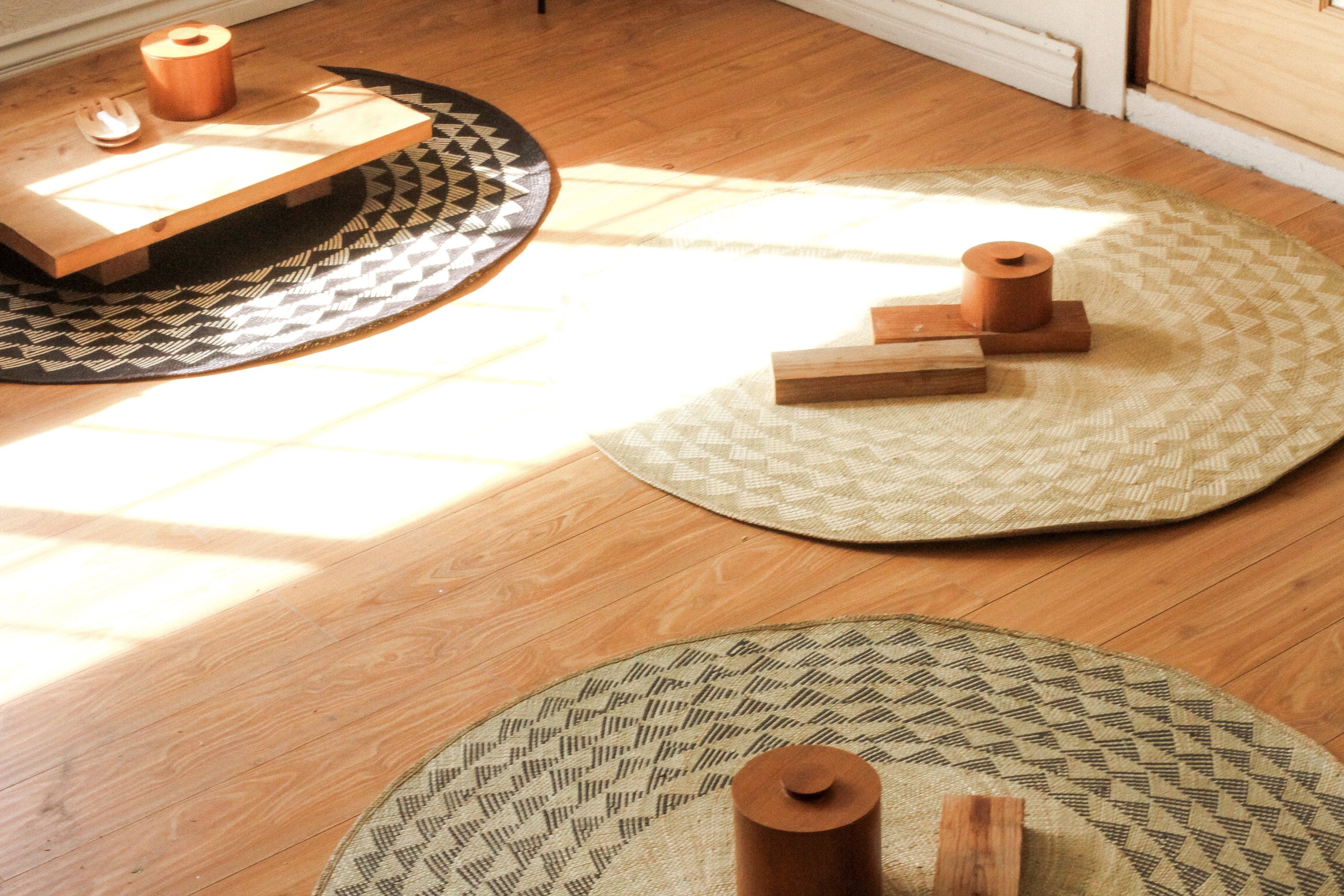 A 4-foot round White Triangle Mat featuring a natural base and white triangle pattern, perfect for indoor and outdoor use.