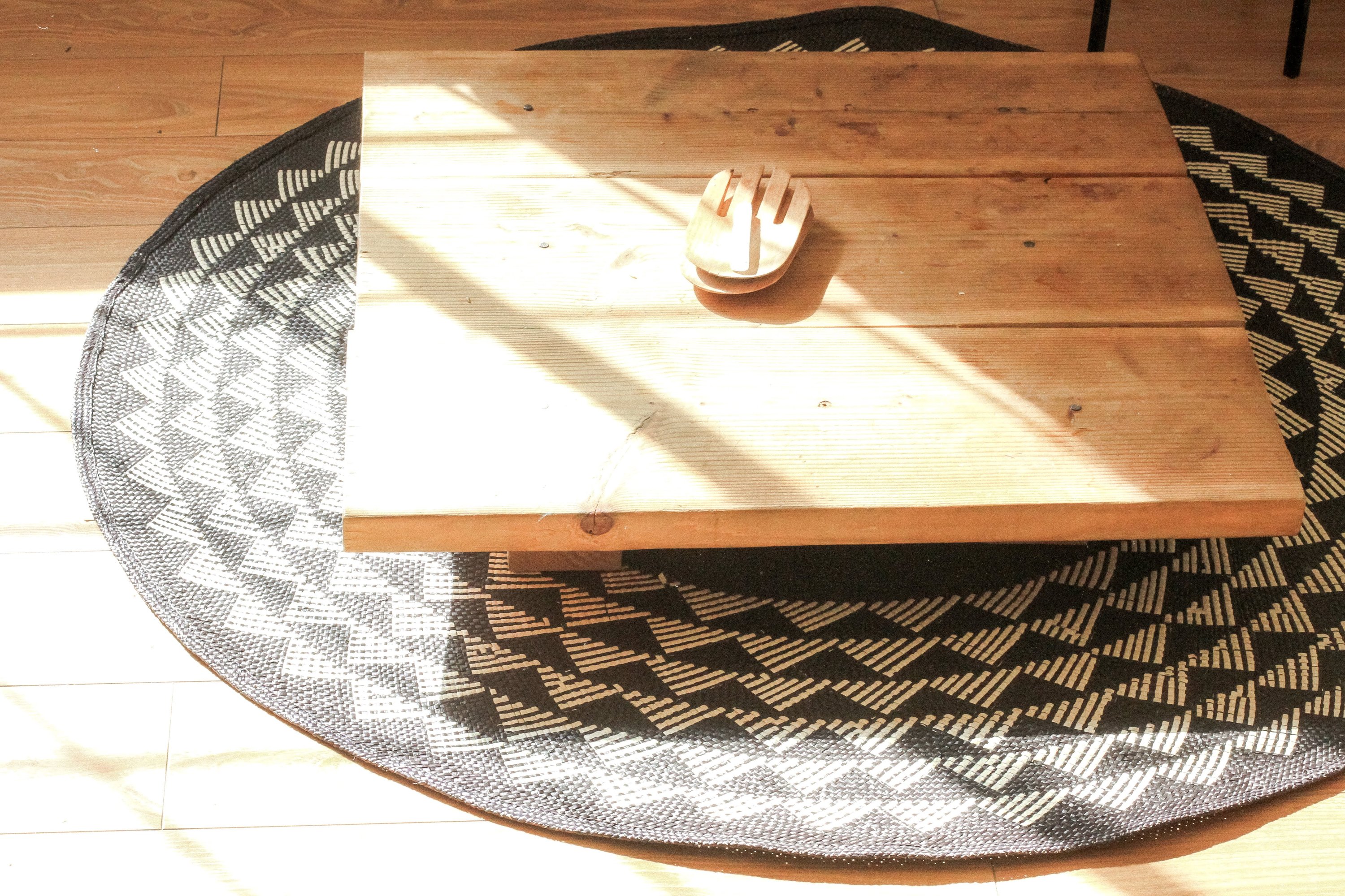 A beautifully crafted 6' round White Triangle Mat with a black base and white triangle pattern, perfect for home decor.