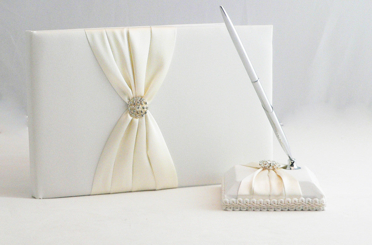 Elegant white wedding guest book set with a silver pen and matching stand, perfect for capturing guest messages.