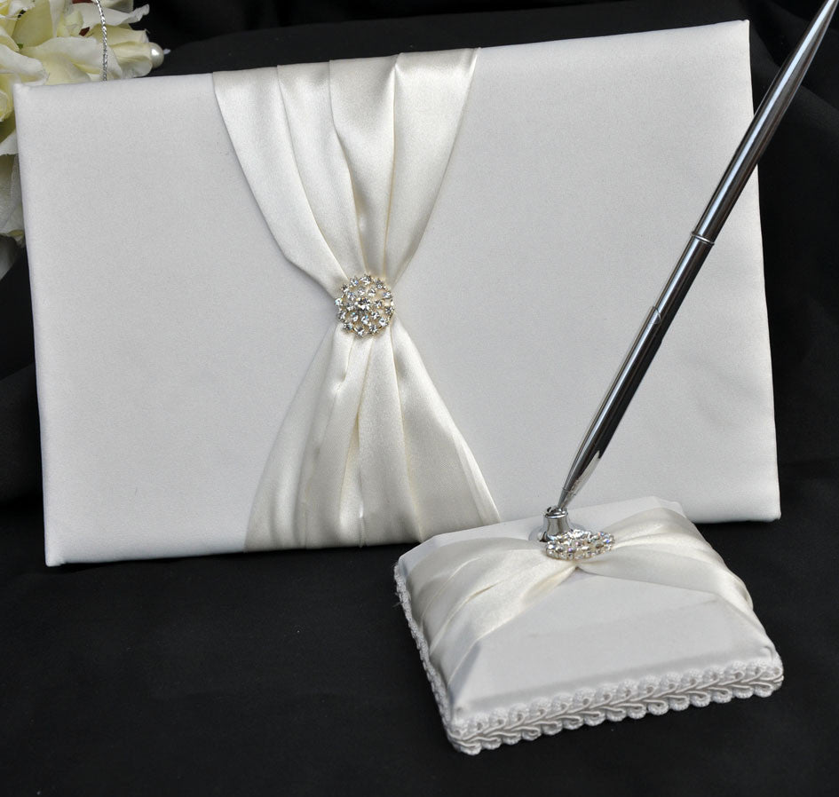 Elegant white wedding guest book set with a silver pen and matching stand, perfect for capturing guest messages.