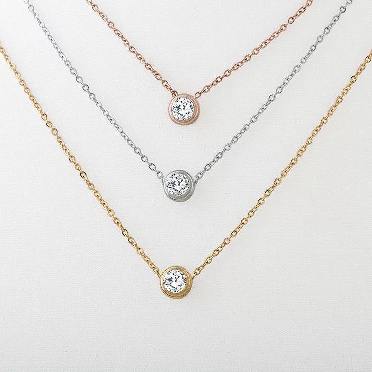 A collection of Wholesale Fashion Stainless Steel Jewelry featuring gold, silver, and rose-plated necklaces with circle-themed pendants.