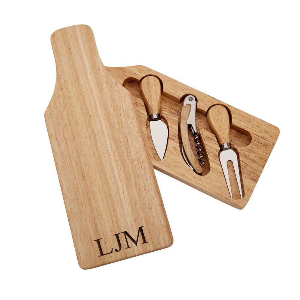 Wine bottle-shaped cheese board with sliding top revealing cheese knife, fork, and corkscrew, made of rubber wood.