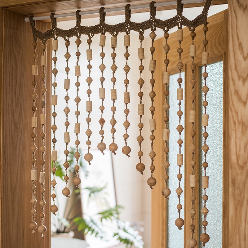 A beautifully crafted Wood Beaded Door Curtain made from solid wood beads and hemp rope, featuring a mix of beige, khaki, and brown colors.