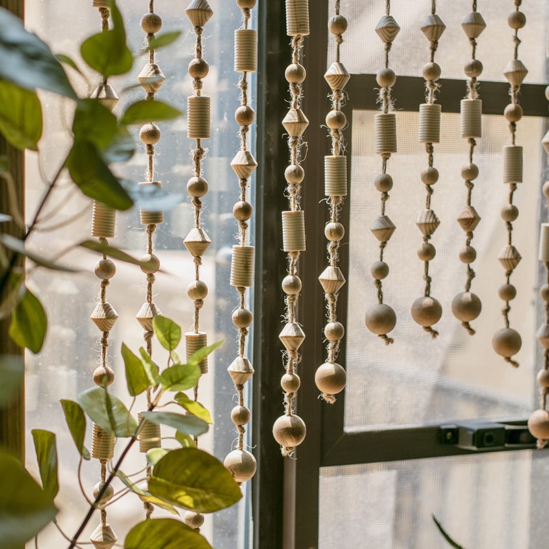 A beautifully crafted Wood Beaded Door Curtain made from solid wood beads and hemp rope, featuring a mix of beige, khaki, and brown colors.