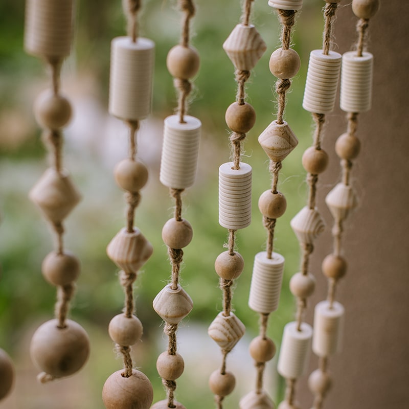 A beautifully crafted Wood Beaded Door Curtain made from solid wood beads and hemp rope, featuring a mix of beige, khaki, and brown colors.